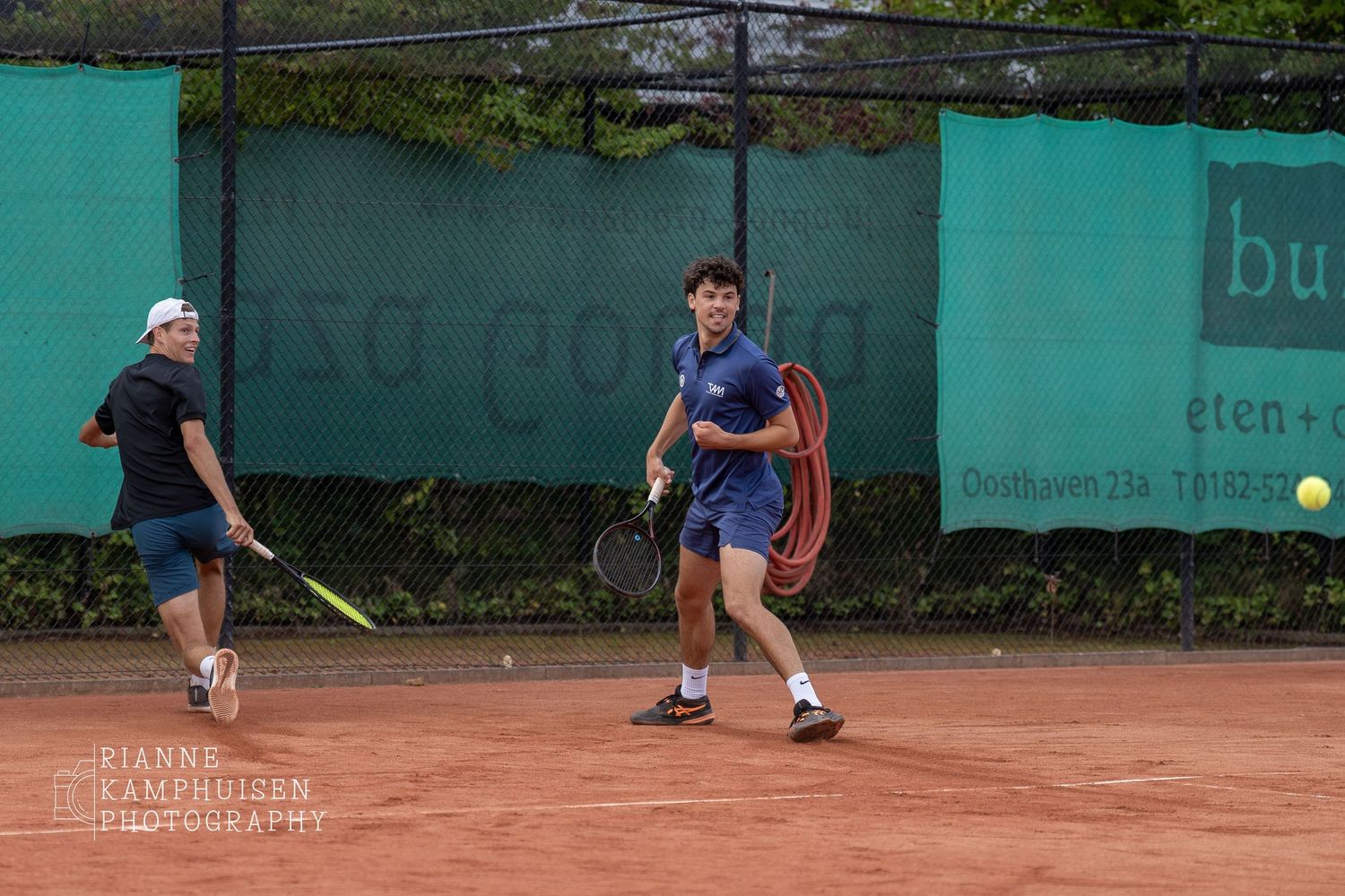 Actiefoto's en finalisten van een gravel tennistoernooi met spelers in actie, dubbelspel, toeschouwers en zomerse sfeer rond de baan.