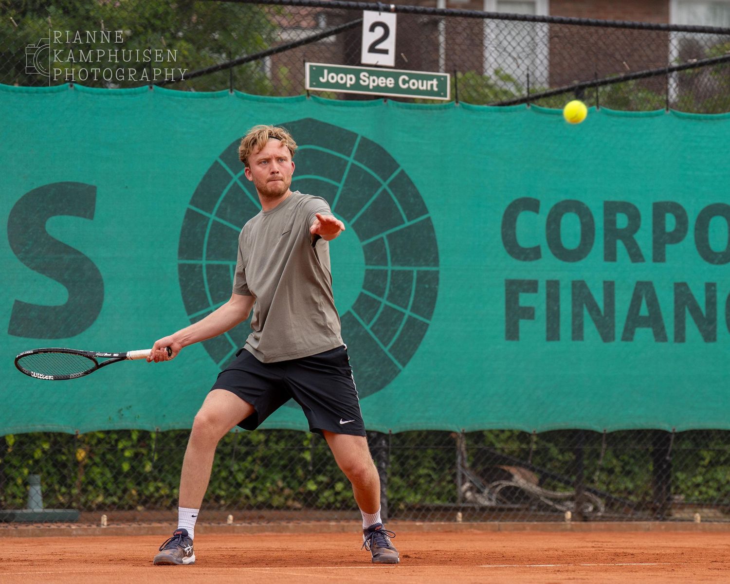 Actiefoto's van gravel tennistoernooi met spelers in actie, dubbelspel, toeschouwers en zomerse sfeer rond de baan.
