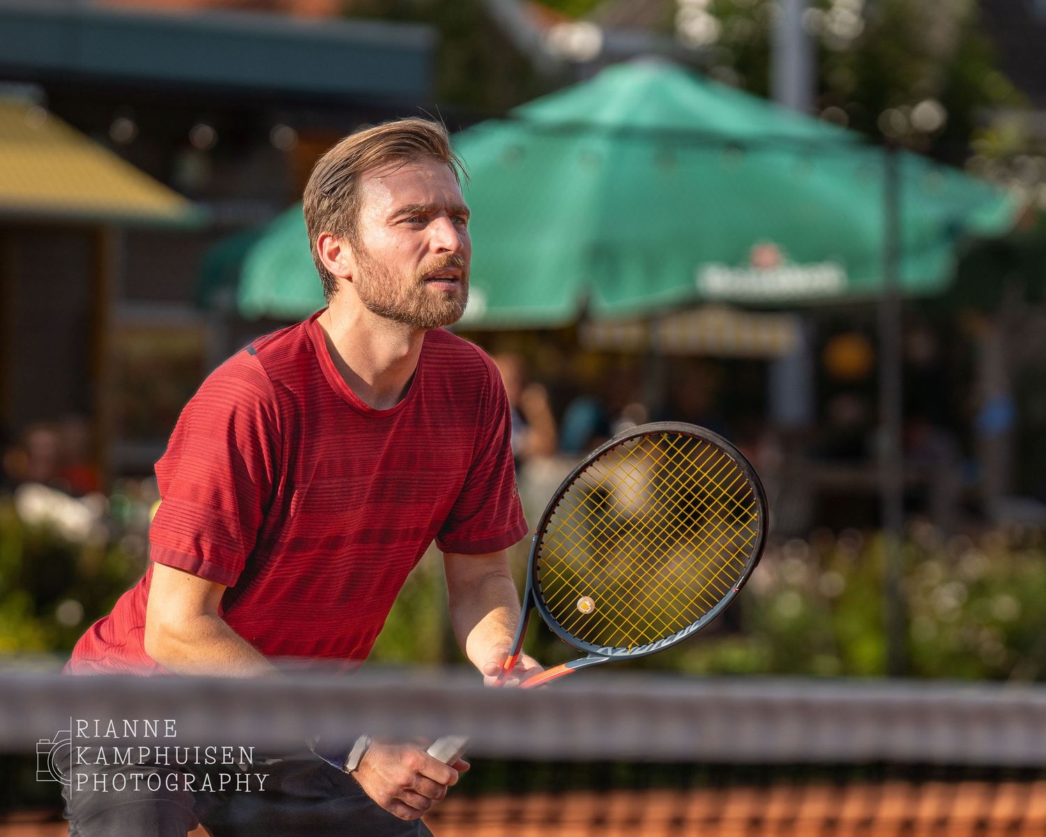 Actiefoto's van gravel tennistoernooi met spelers in actie, dubbelspel, toeschouwers en zomerse sfeer rond de baan.