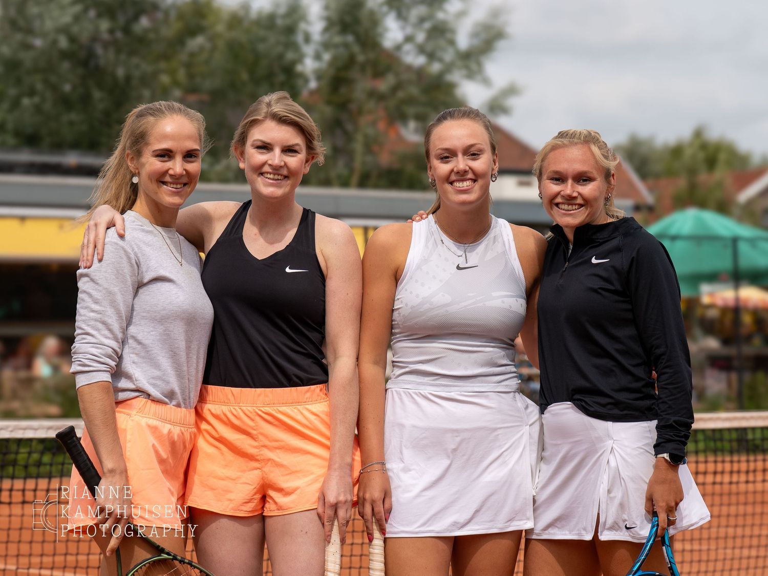 Actiefoto's en finalisten van een gravel tennistoernooi met spelers in actie, dubbelspel, toeschouwers en zomerse sfeer rond de baan.