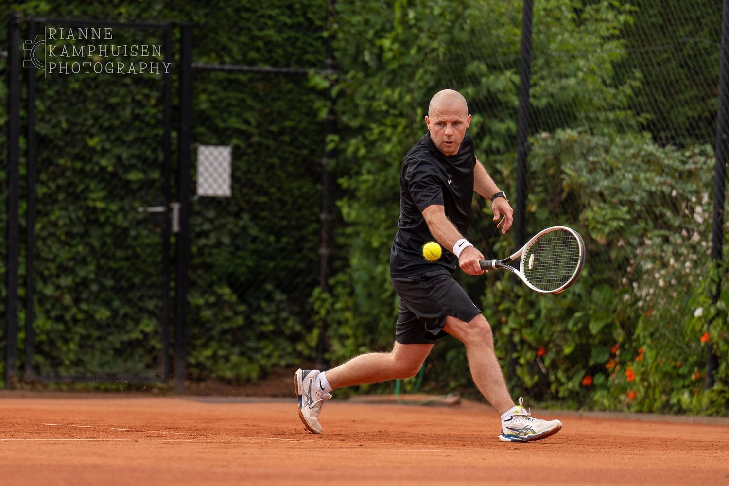 Actiefoto's van gravel tennistoernooi met spelers in actie, dubbelspel, toeschouwers en zomerse sfeer rond de baan.