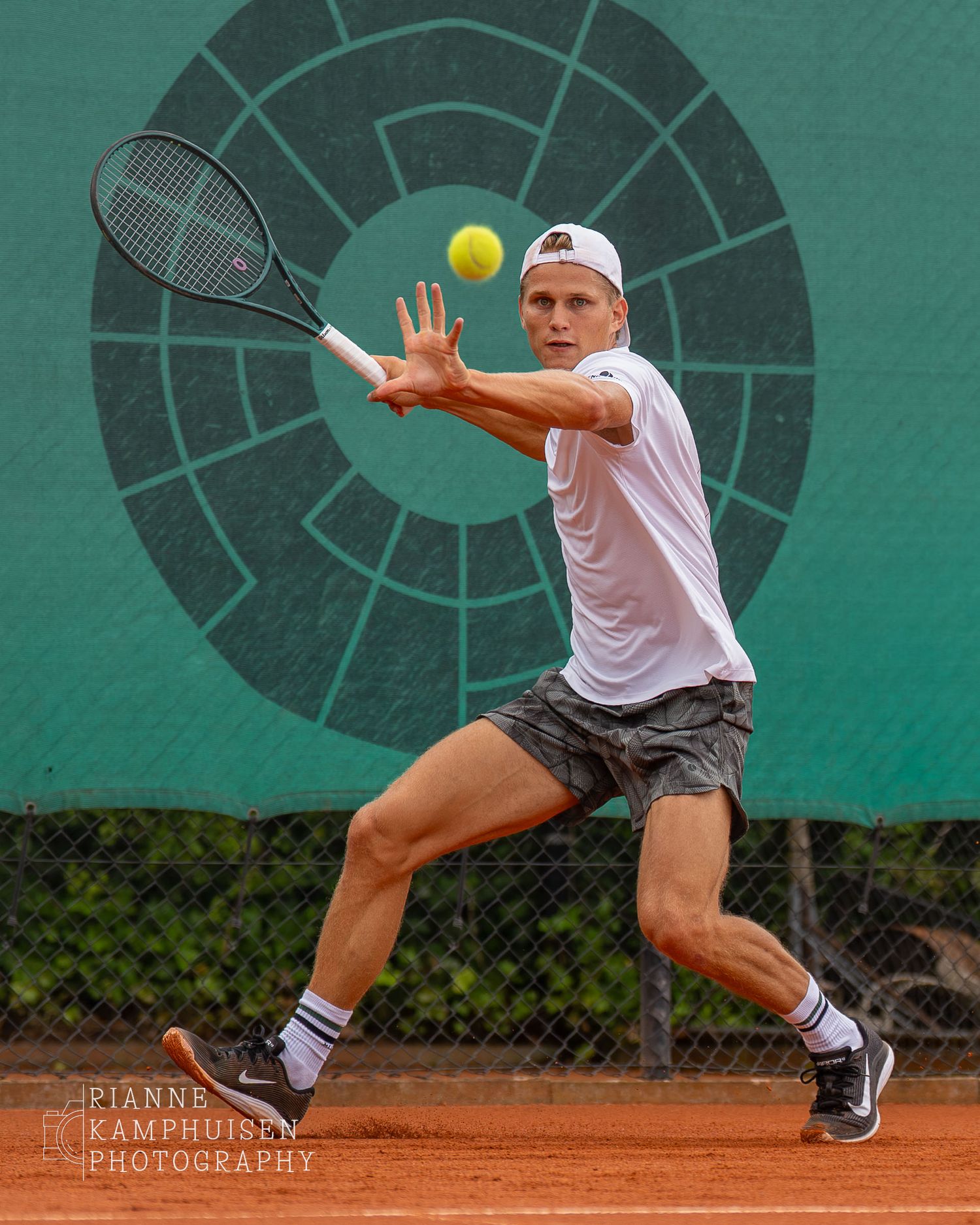 Actiefoto's van de zaterdag van een gravel tennistoernooi met spelers in actie, dubbelspel, toeschouwers en zomerse sfeer rond de baan.