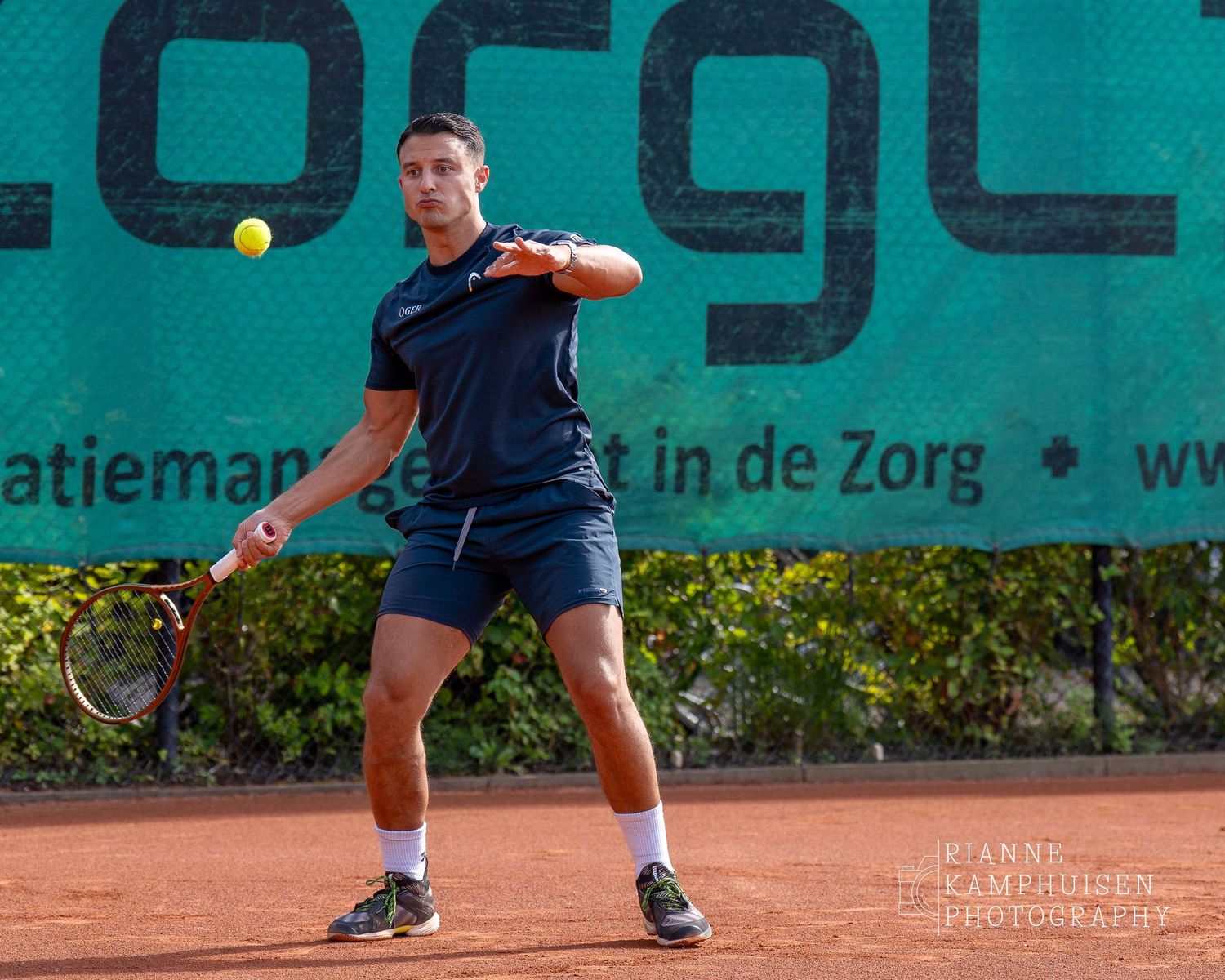 Actiefoto's van de woensdagavond van eengravel tennistoernooi met spelers in actie, dubbelspel, toeschouwers en zomerse sfeer rond de baan.