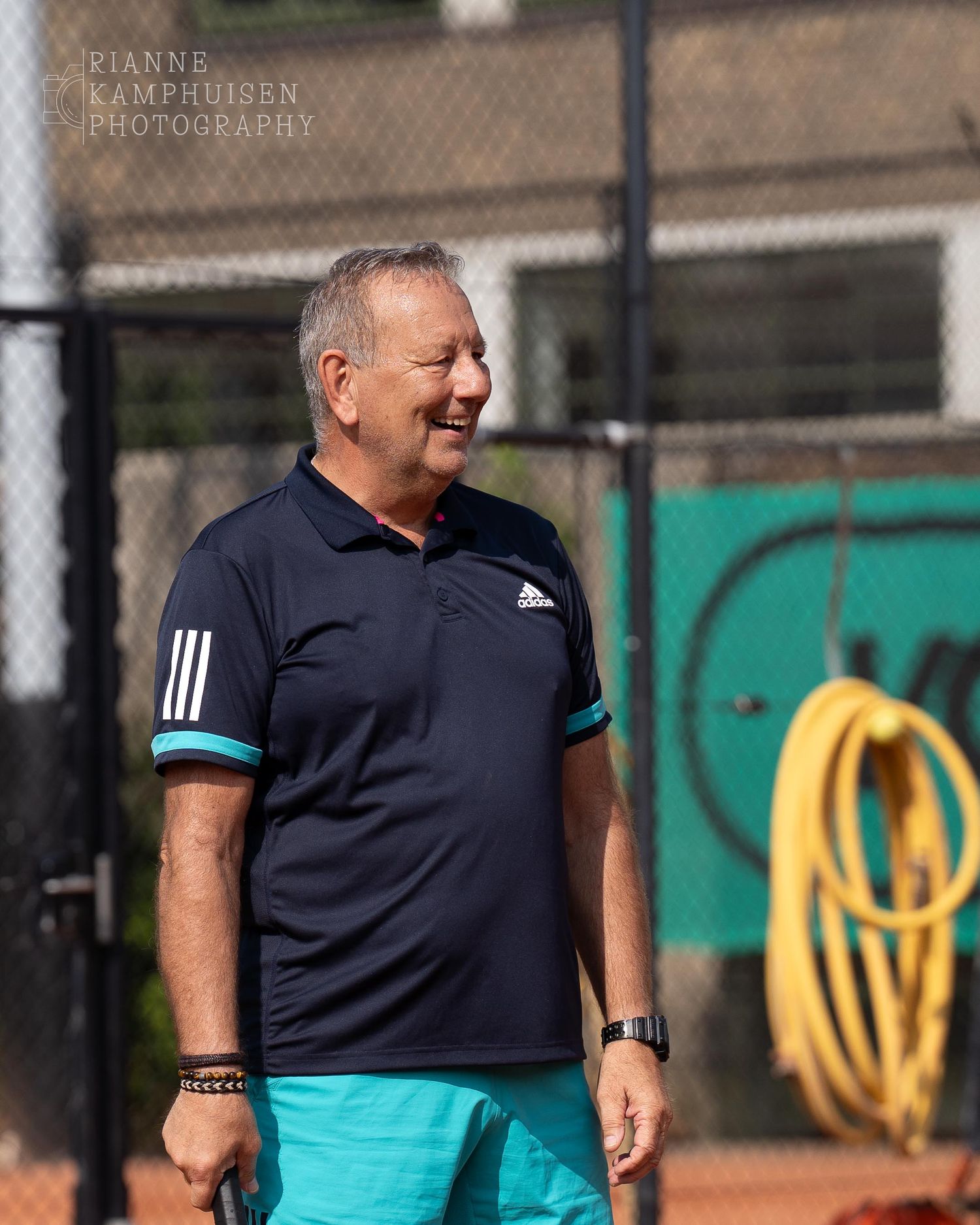 Actiefoto's van gravel tennistoernooi met spelers in actie, dubbelspel, toeschouwers en zomerse sfeer rond de baan.