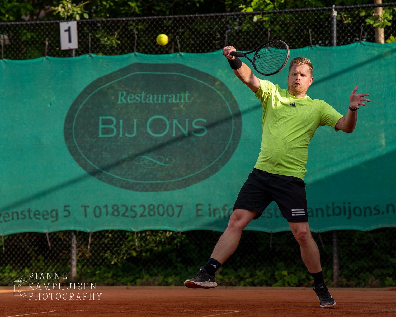 Actiefoto's van gravel tennistoernooi met spelers in actie, dubbelspel, toeschouwers en zomerse sfeer rond de baan.