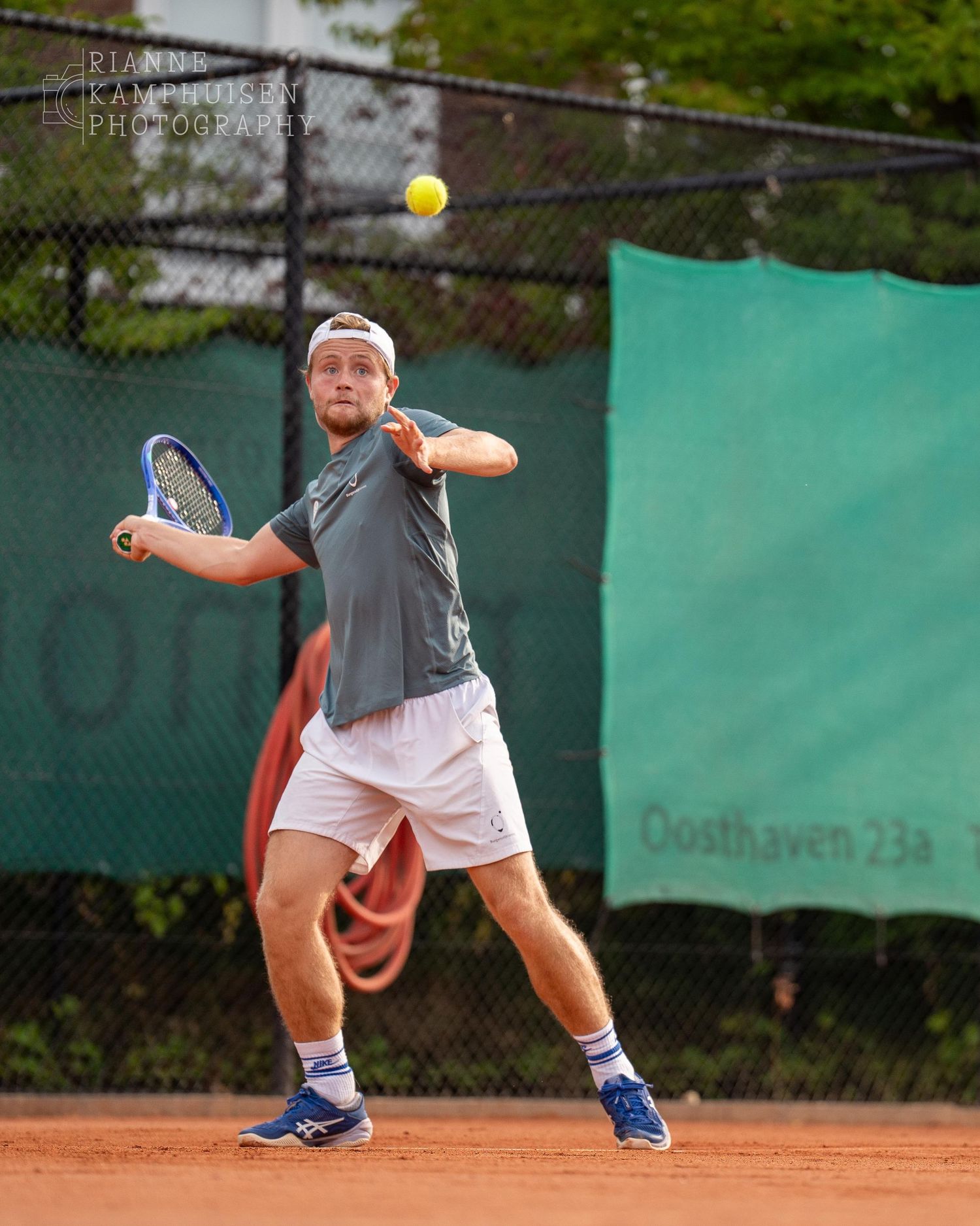 Actiefoto's van gravel tennistoernooi met spelers in actie, dubbelspel, toeschouwers en zomerse sfeer rond de baan.