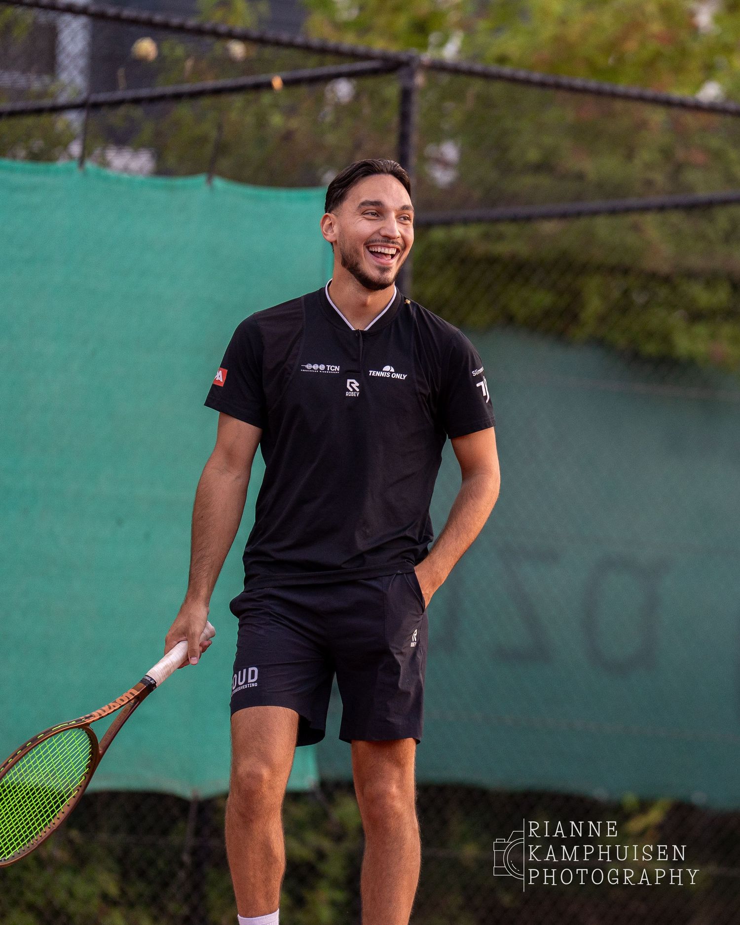 Actiefoto's van gravel tennistoernooi met spelers in actie, dubbelspel, toeschouwers en zomerse sfeer rond de baan.
