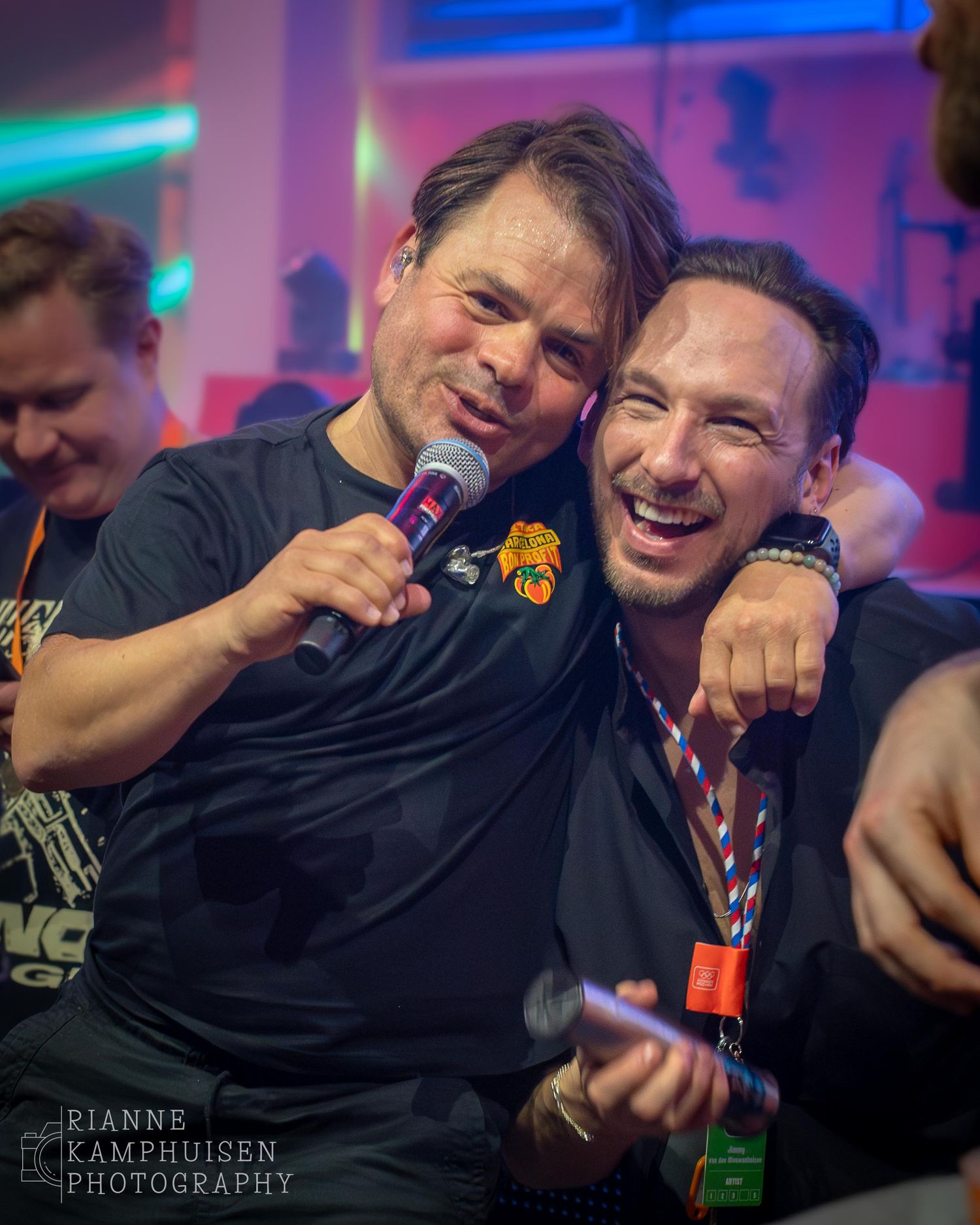 Roel van Velzen en bandleider Jim van The Jimmy's in een omhelzing waarbij ze al lachend recht in de camera kijken