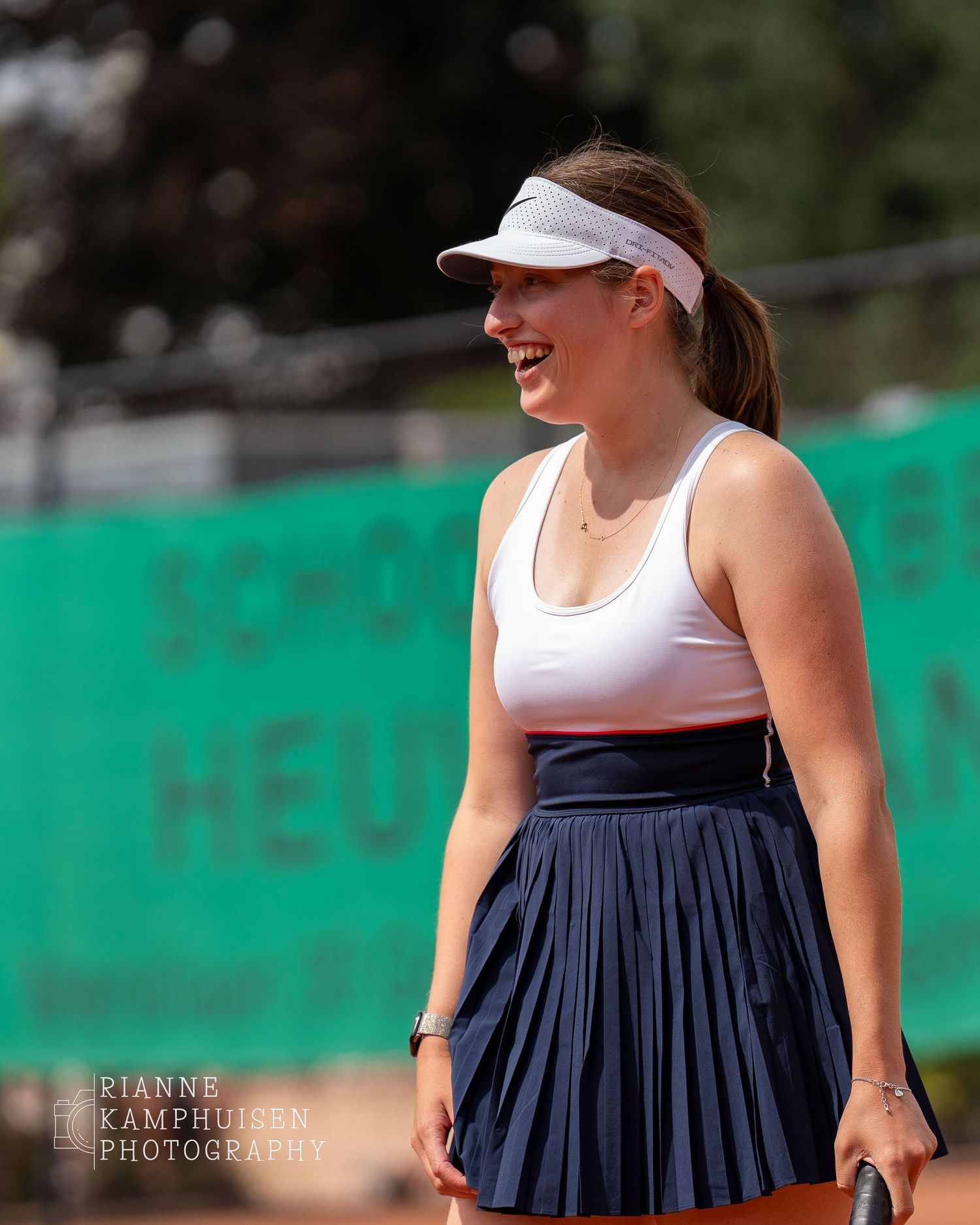 Actiefoto's en finalisten van een gravel tennistoernooi met spelers in actie, dubbelspel, toeschouwers en zomerse sfeer rond de baan.
