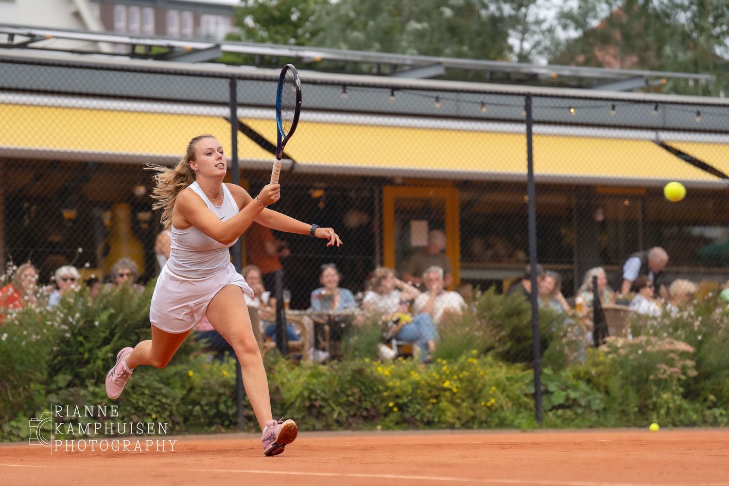 Actiefoto's en finalisten van een gravel tennistoernooi met spelers in actie, dubbelspel, toeschouwers en zomerse sfeer rond de baan.