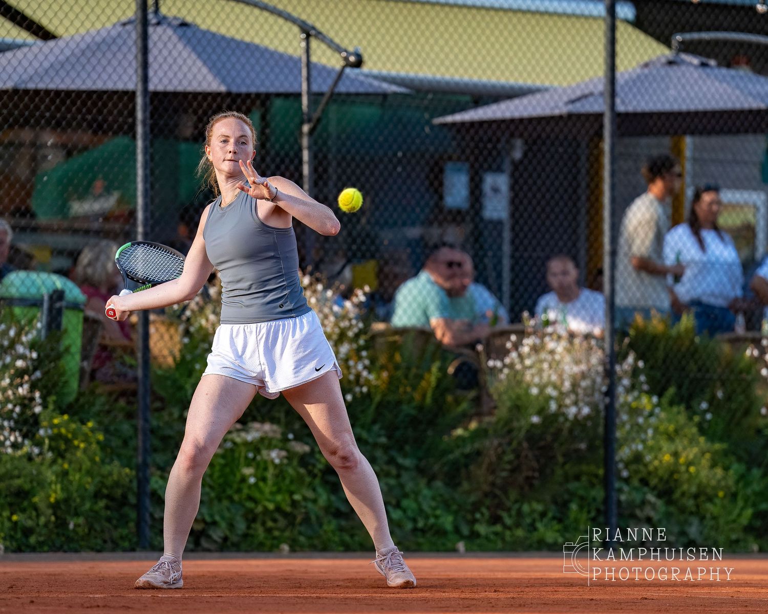 Actiefoto's van de woensdagavond van eengravel tennistoernooi met spelers in actie, dubbelspel, toeschouwers en zomerse sfeer rond de baan.