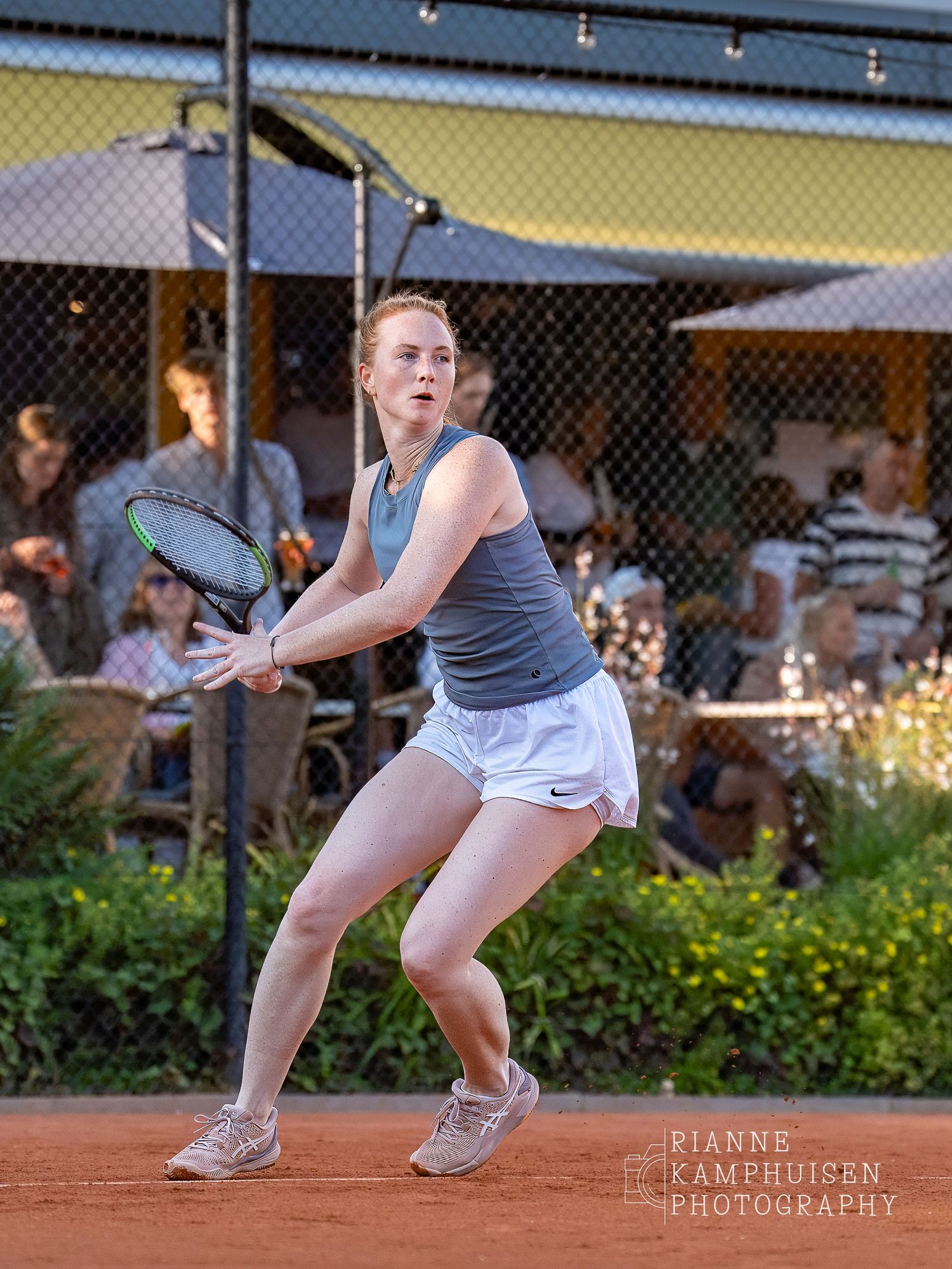 Actiefoto's van de woensdagavond van eengravel tennistoernooi met spelers in actie, dubbelspel, toeschouwers en zomerse sfeer rond de baan.