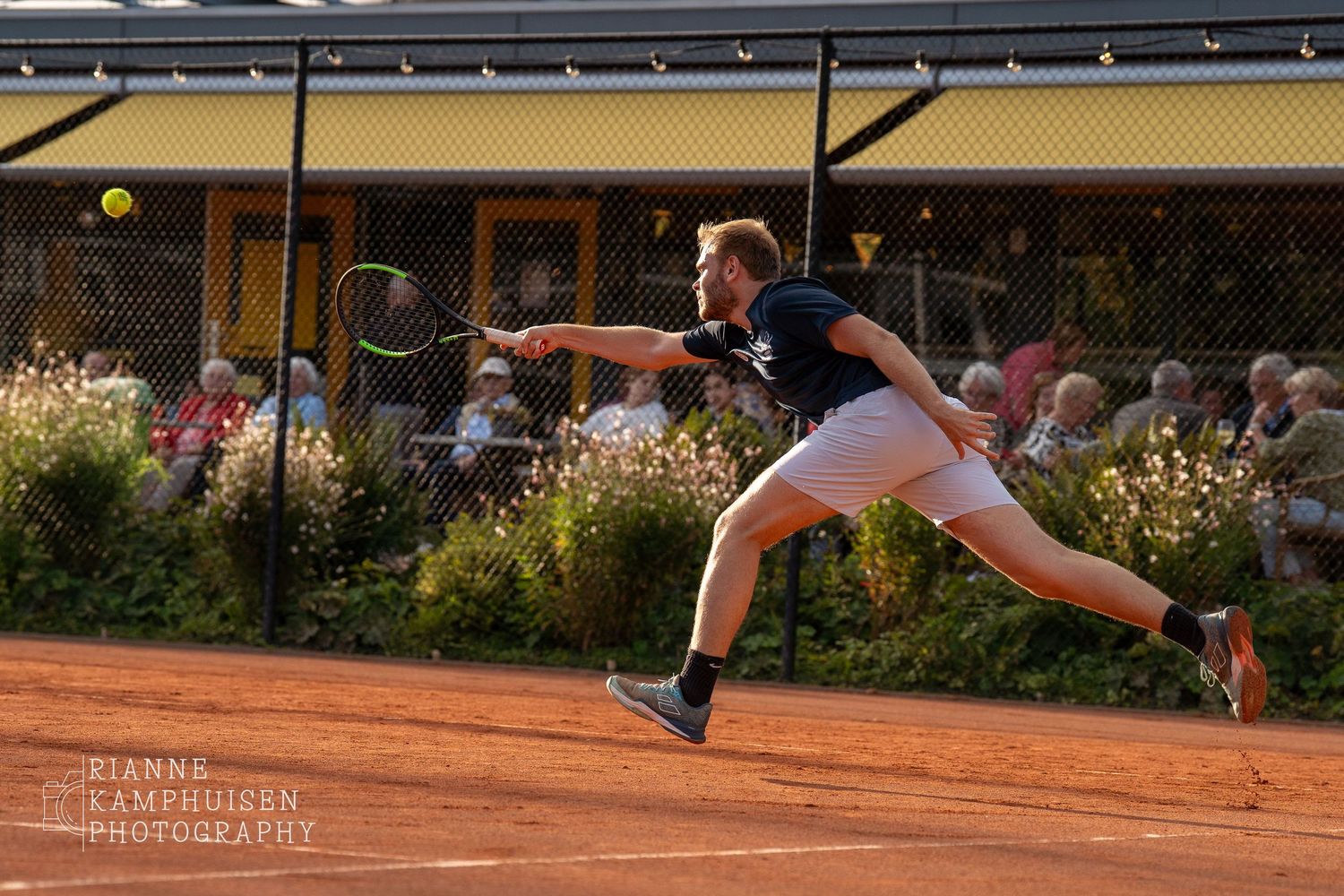 Actiefoto's van gravel tennistoernooi met spelers in actie, dubbelspel, toeschouwers en zomerse sfeer rond de baan.