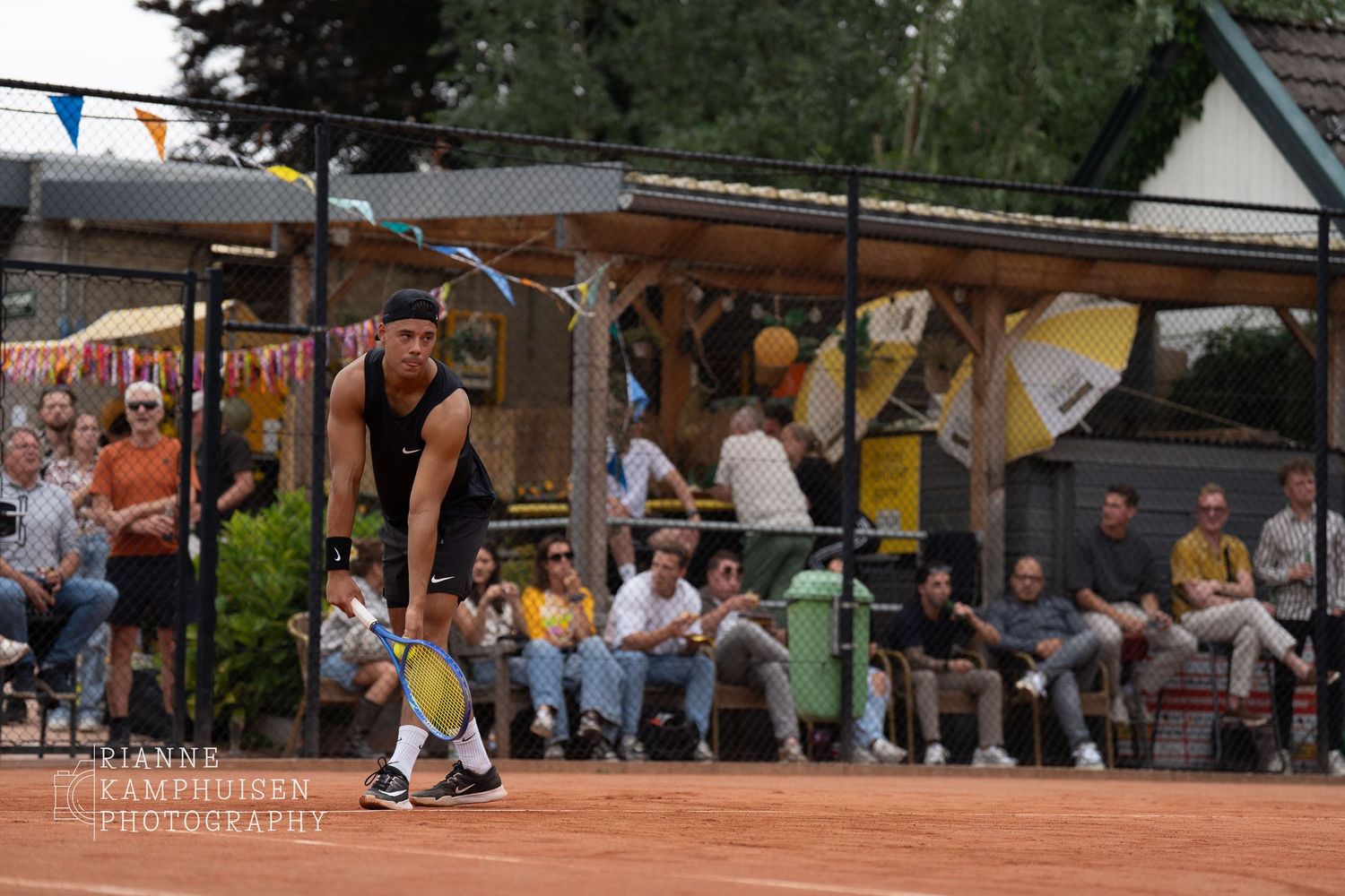 Actiefoto's en finalisten van een gravel tennistoernooi met spelers in actie, dubbelspel, toeschouwers en zomerse sfeer rond de baan.