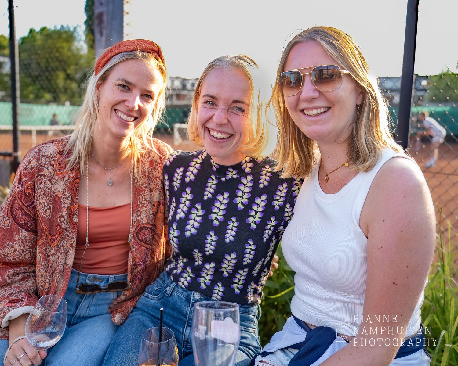 Actiefoto's van de woensdagavond van eengravel tennistoernooi met spelers in actie, dubbelspel, toeschouwers en zomerse sfeer rond de baan.