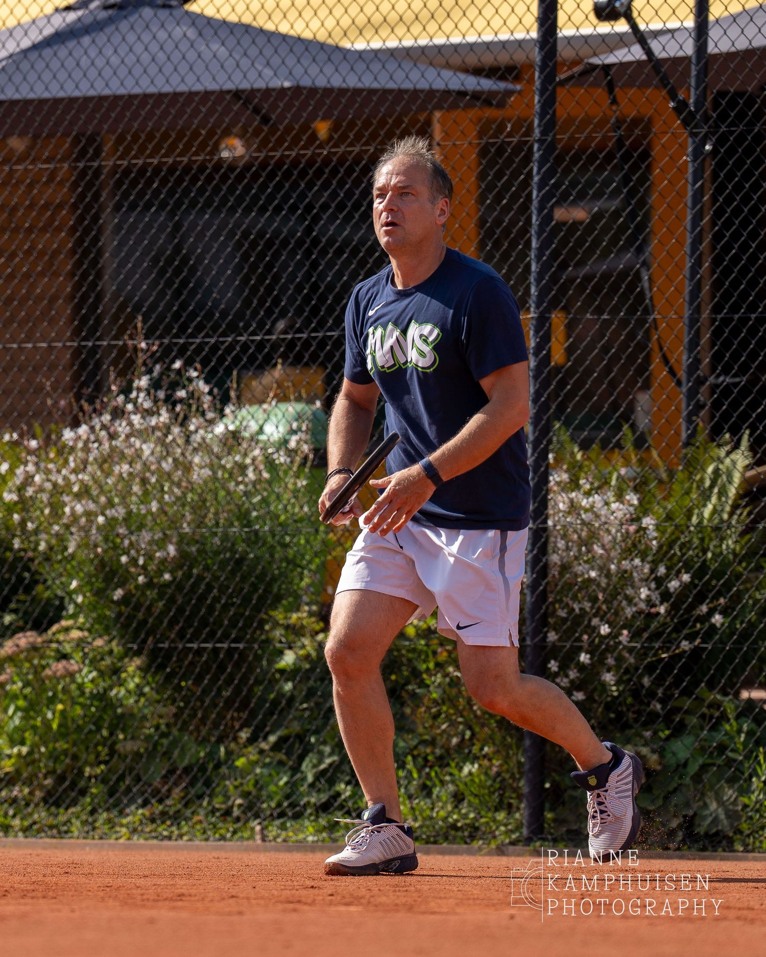 Actiefoto's van de woensdagavond van eengravel tennistoernooi met spelers in actie, dubbelspel, toeschouwers en zomerse sfeer rond de baan.
