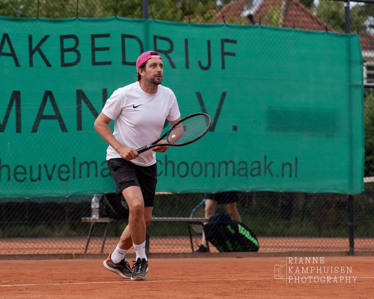 Actiefoto's van gravel tennistoernooi met spelers in actie, dubbelspel, toeschouwers en zomerse sfeer rond de baan.