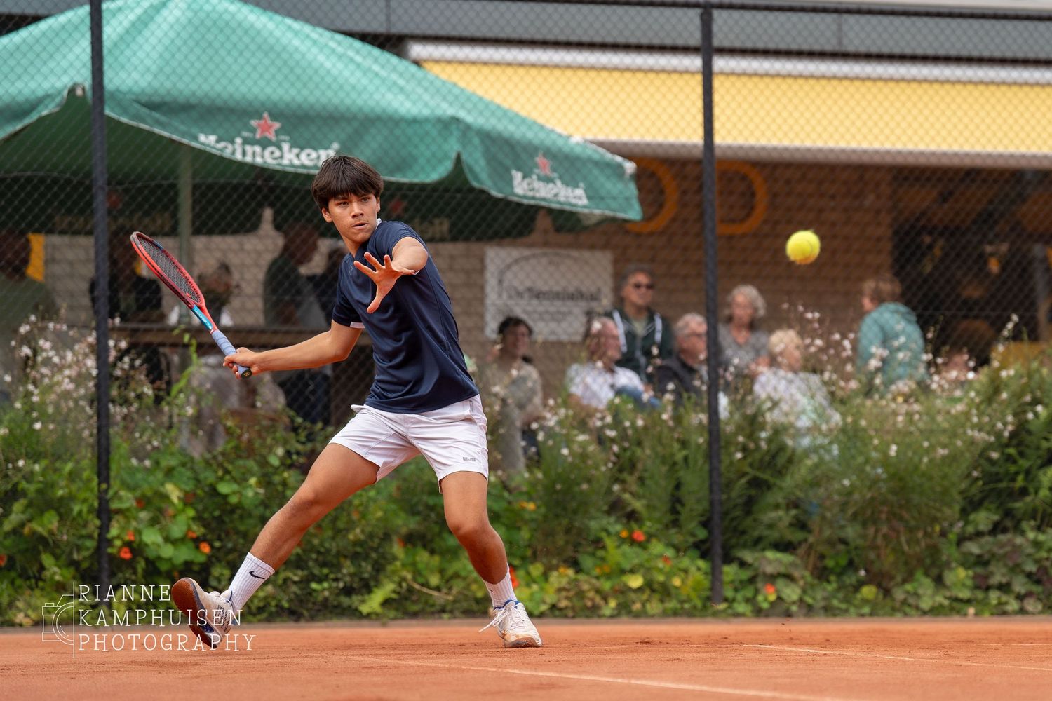 Actiefoto's en finalisten van een gravel tennistoernooi met spelers in actie, dubbelspel, toeschouwers en zomerse sfeer rond de baan.