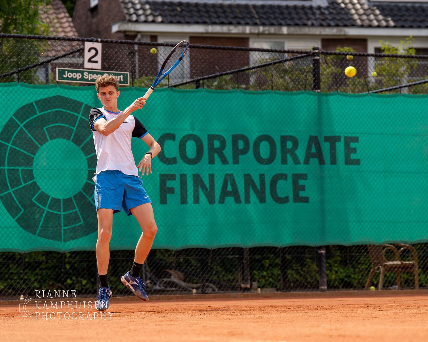 Actiefoto's en finalisten van een gravel tennistoernooi met spelers in actie, dubbelspel, toeschouwers en zomerse sfeer rond de baan.