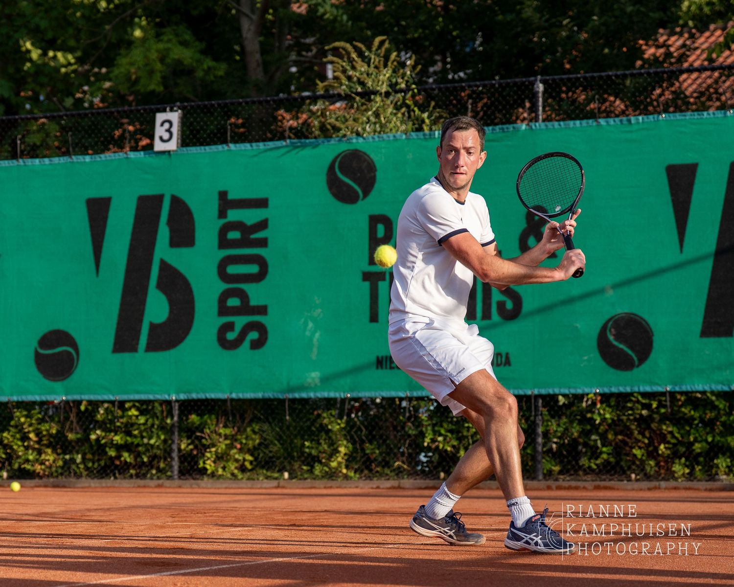 Actiefoto's van de vrijdagavond van een gravel tennistoernooi met spelers in actie, dubbelspel, toeschouwers en zomerse sfeer rond de baan.