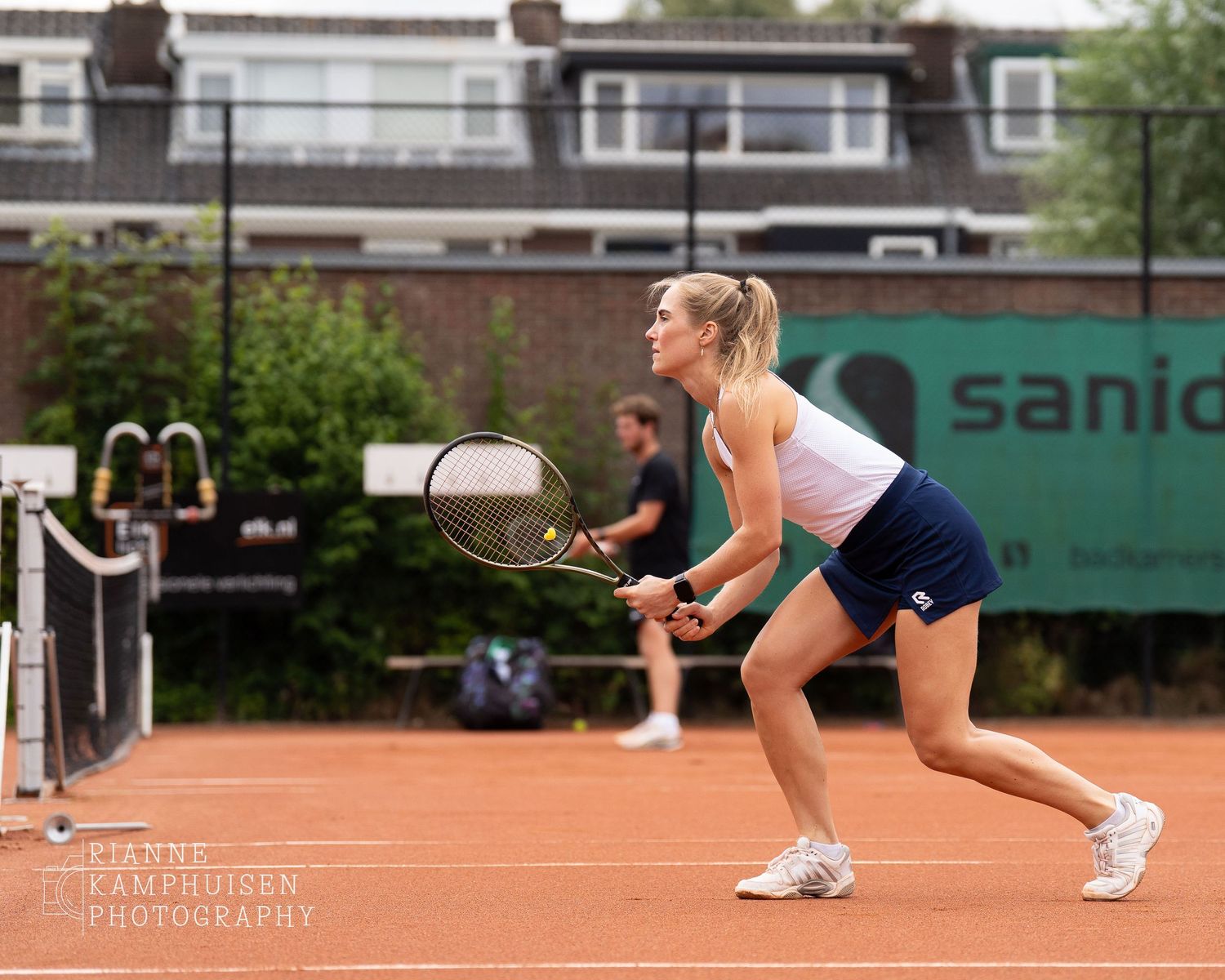 Actiefoto's van de zaterdag van een gravel tennistoernooi met spelers in actie, dubbelspel, toeschouwers en zomerse sfeer rond de baan.
