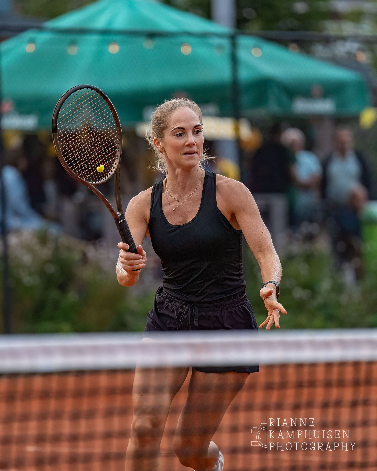 Actiefoto's van de woensdagavond van eengravel tennistoernooi met spelers in actie, dubbelspel, toeschouwers en zomerse sfeer rond de baan.