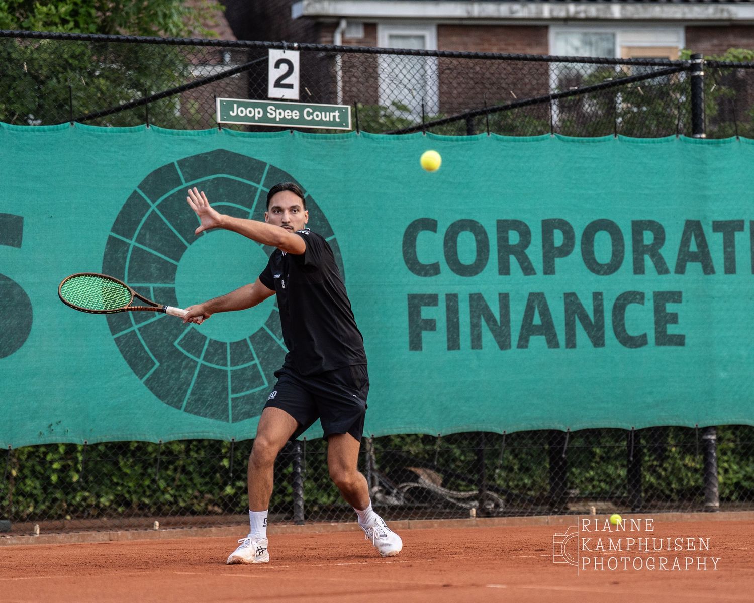 Actiefoto's van gravel tennistoernooi met spelers in actie, dubbelspel, toeschouwers en zomerse sfeer rond de baan.