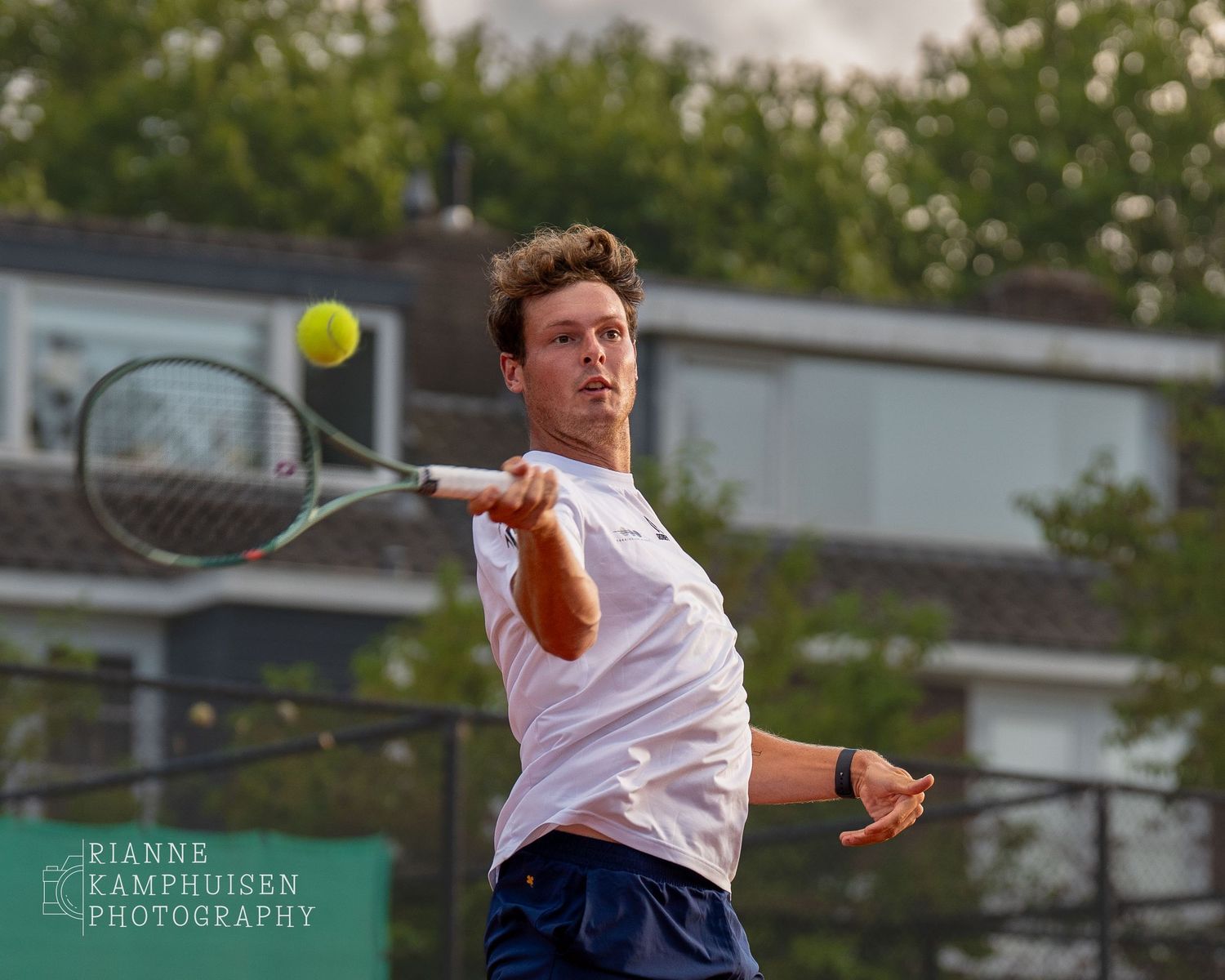 Actiefoto's van gravel tennistoernooi met spelers in actie, dubbelspel, toeschouwers en zomerse sfeer rond de baan.