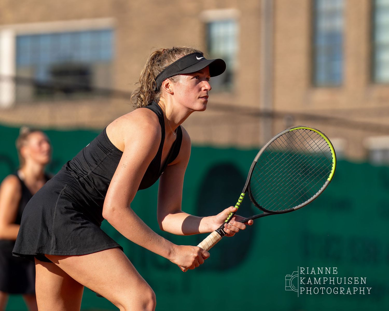 Actiefoto's van de woensdagavond van eengravel tennistoernooi met spelers in actie, dubbelspel, toeschouwers en zomerse sfeer rond de baan.