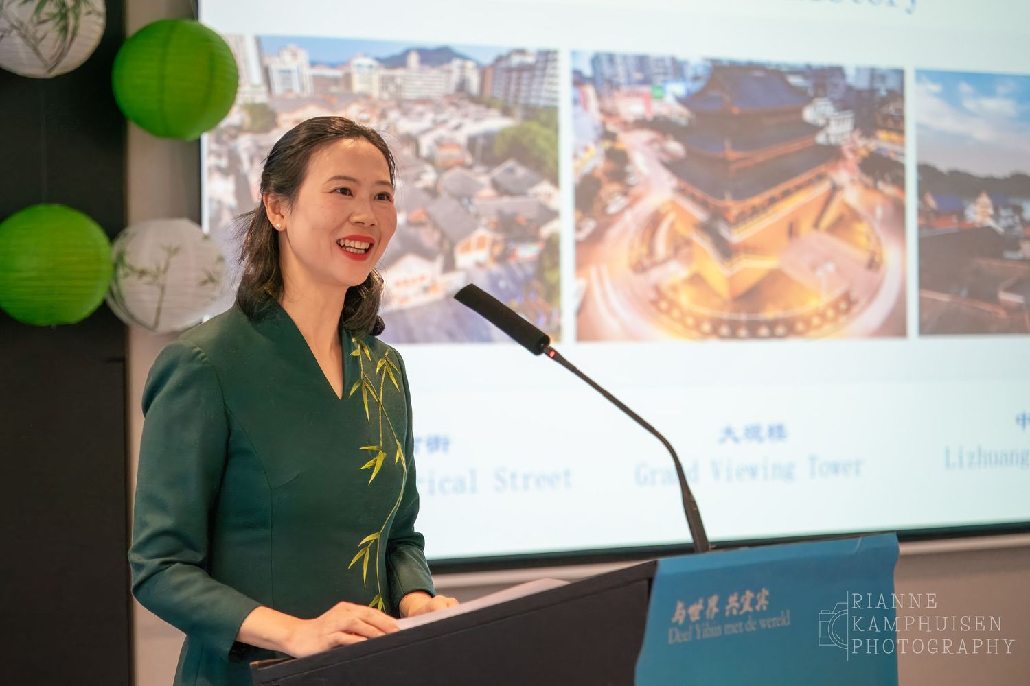 Spreker op het podium tijdens de culturele conferentie over Yibin, met presentatie over toerisme.