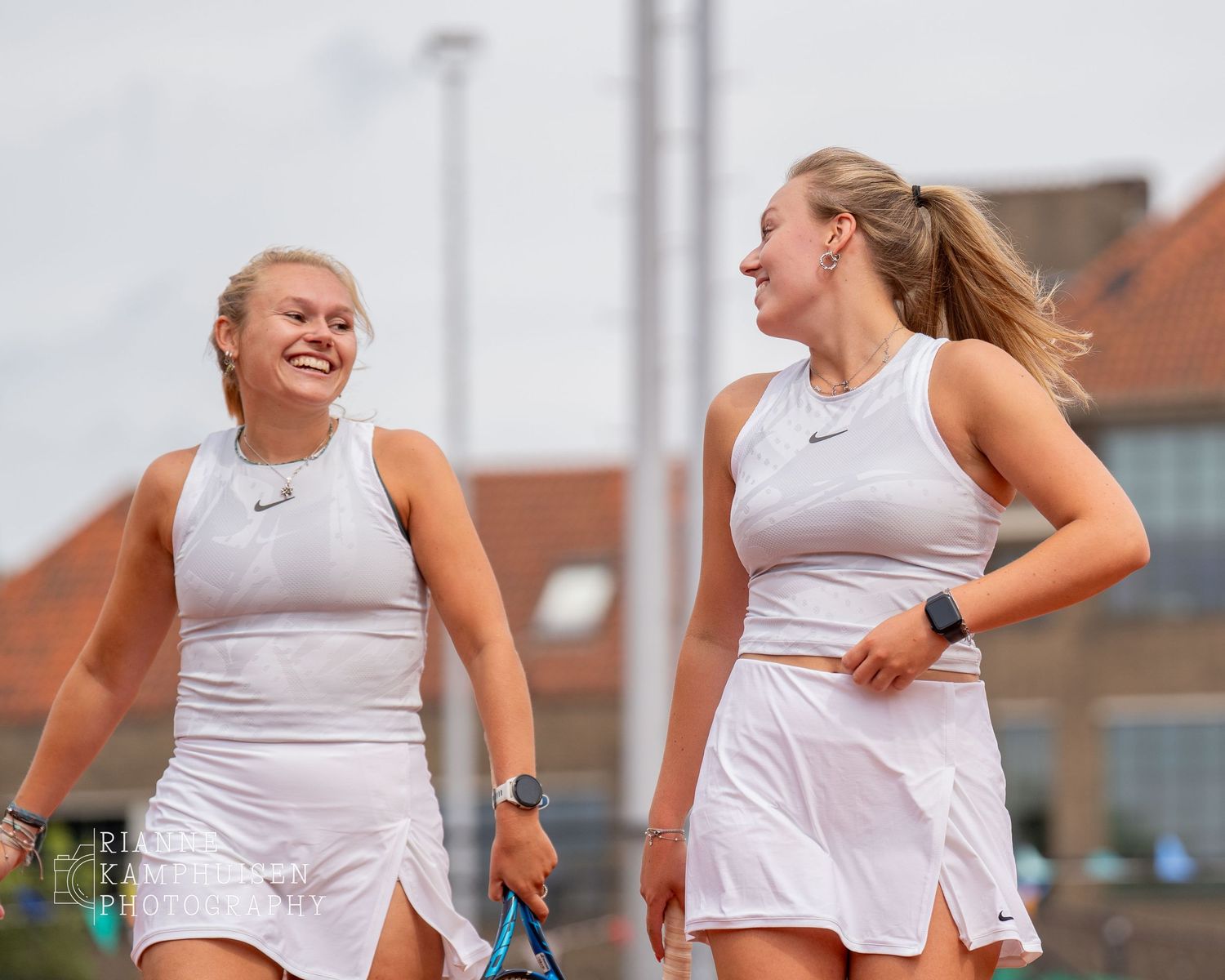 Actiefoto's en finalisten van een gravel tennistoernooi met spelers in actie, dubbelspel, toeschouwers en zomerse sfeer rond de baan.