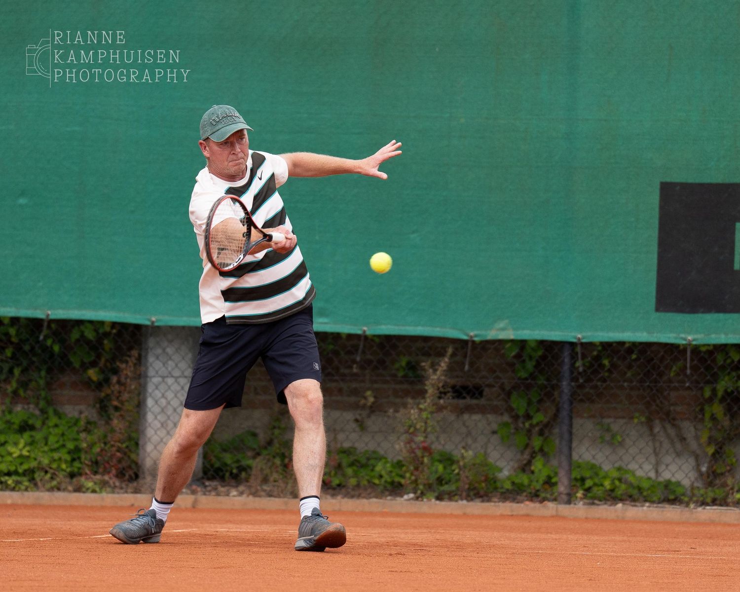 Actiefoto's van gravel tennistoernooi met spelers in actie, dubbelspel, toeschouwers en zomerse sfeer rond de baan.