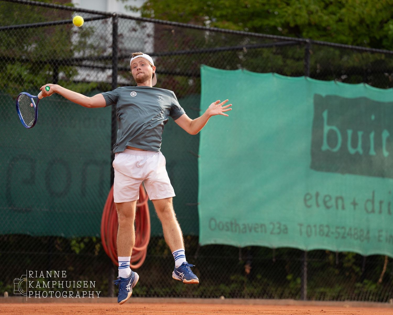 Actiefoto's van gravel tennistoernooi met spelers in actie, dubbelspel, toeschouwers en zomerse sfeer rond de baan.