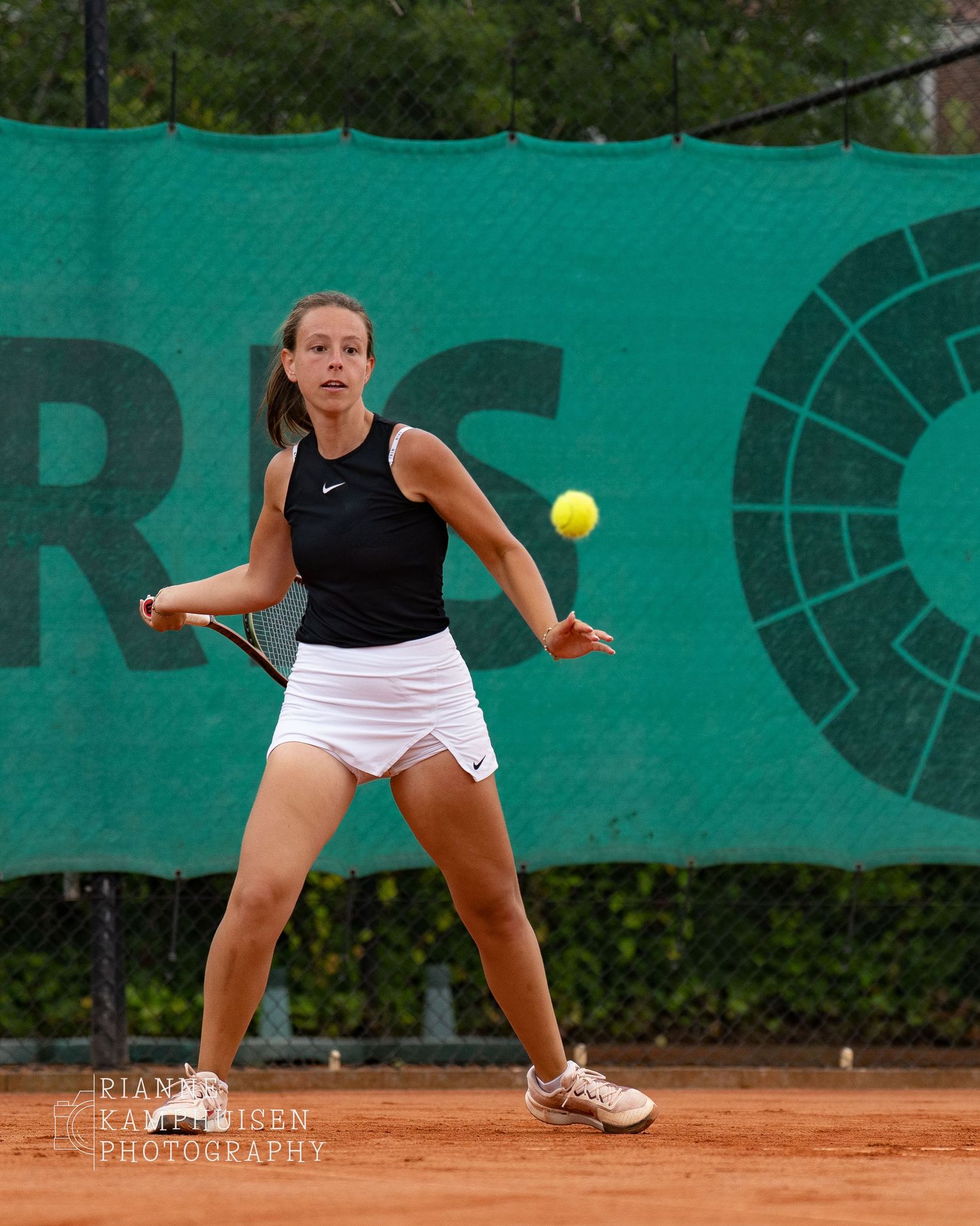 Actiefoto's en finalisten van een gravel tennistoernooi met spelers in actie, dubbelspel, toeschouwers en zomerse sfeer rond de baan.