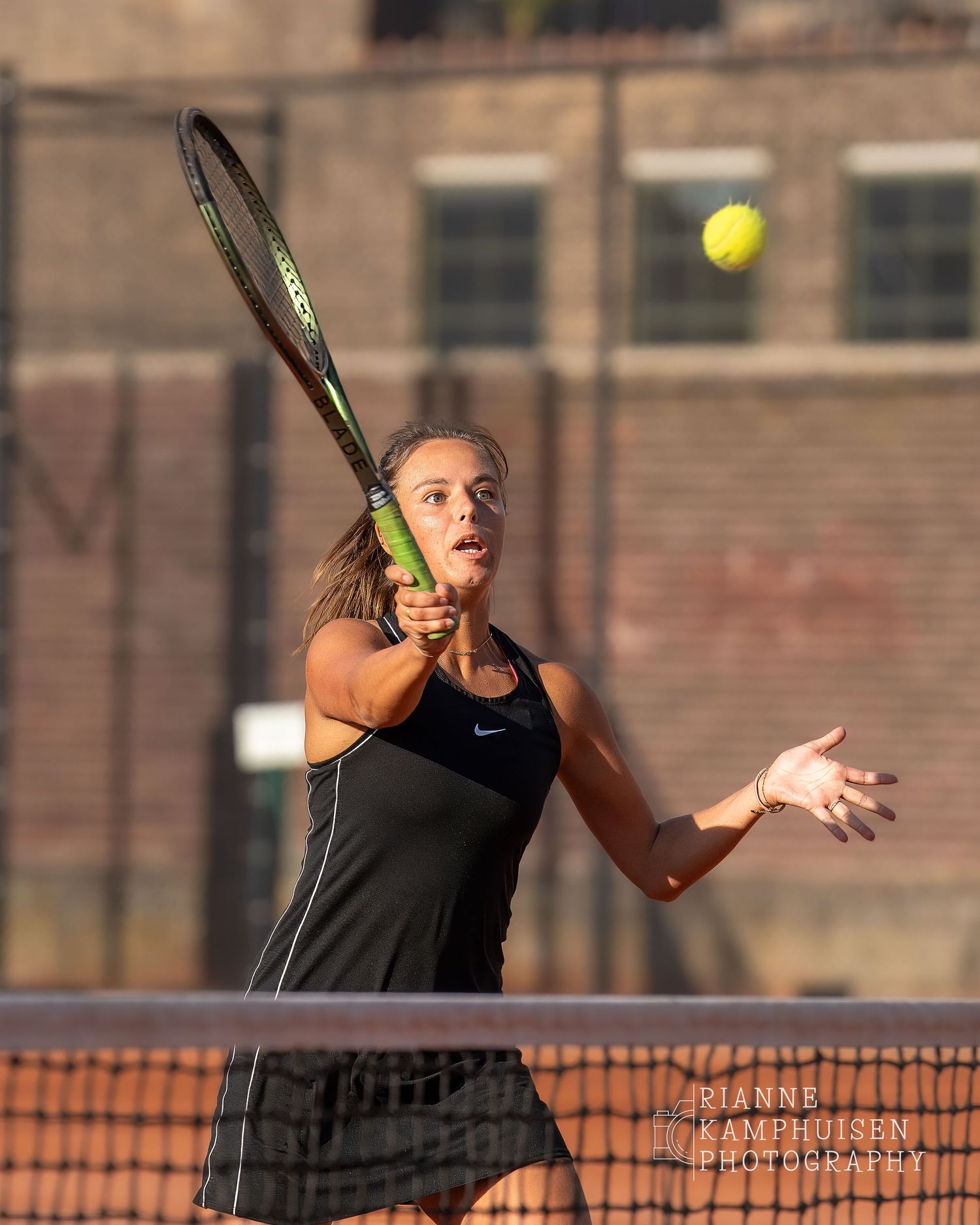 Actiefoto's van de woensdagavond van eengravel tennistoernooi met spelers in actie, dubbelspel, toeschouwers en zomerse sfeer rond de baan.