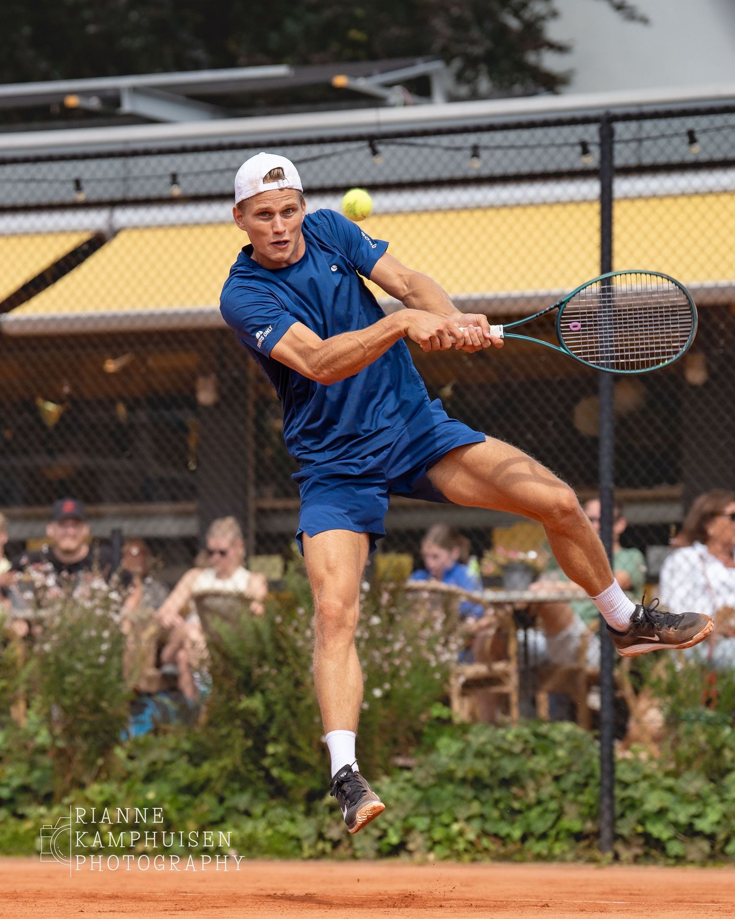 Actiefoto's en finalisten van een gravel tennistoernooi met spelers in actie, dubbelspel, toeschouwers en zomerse sfeer rond de baan.