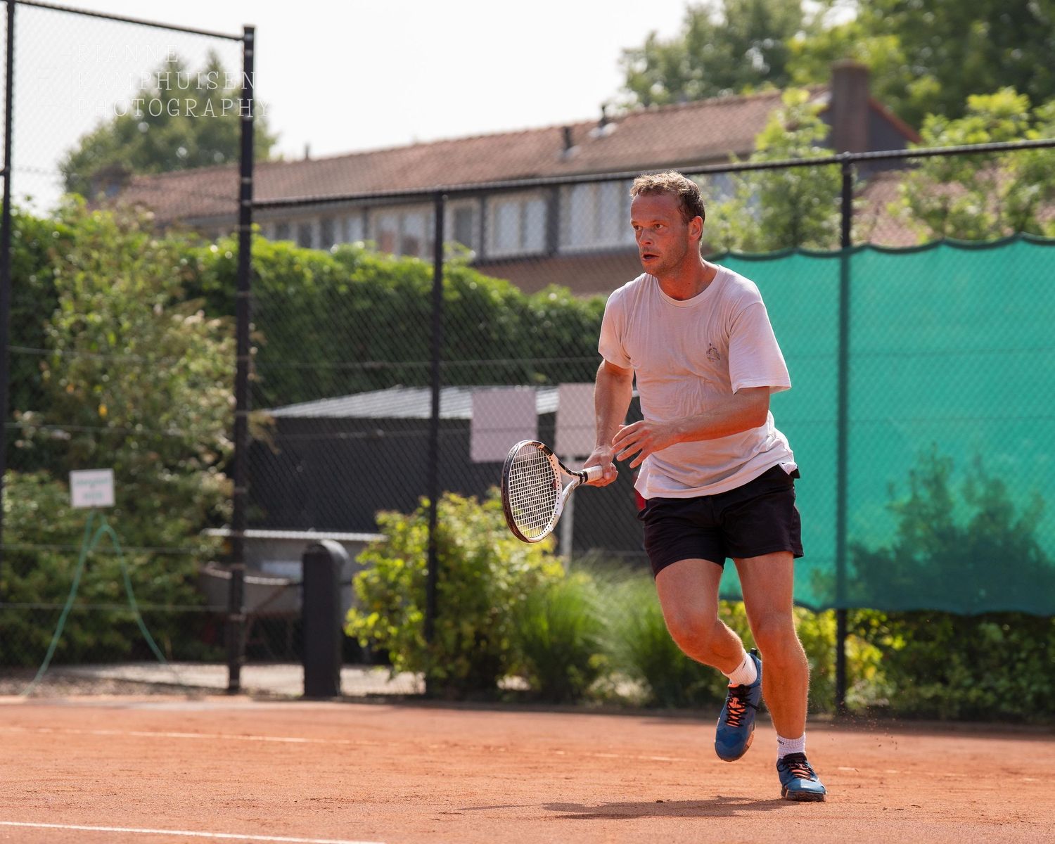 Actiefoto's van gravel tennistoernooi met spelers in actie, dubbelspel, toeschouwers en zomerse sfeer rond de baan.
