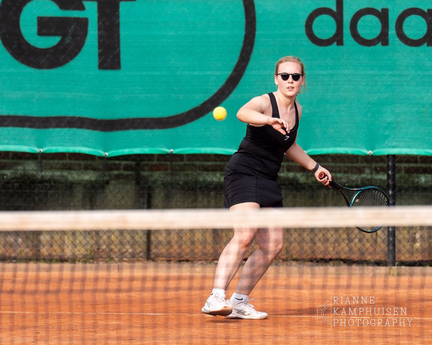 Actiefoto's van gravel tennistoernooi met spelers in actie, dubbelspel, toeschouwers en zomerse sfeer rond de baan.