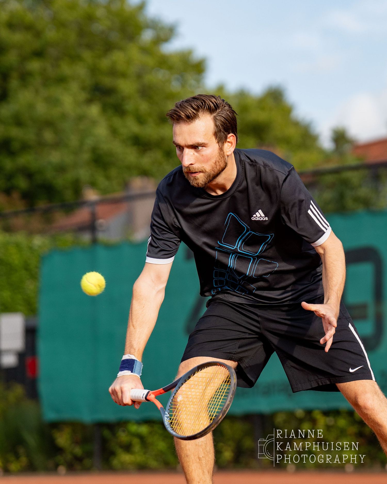 Actiefoto's van de vrijdagavond van een gravel tennistoernooi met spelers in actie, dubbelspel, toeschouwers en zomerse sfeer rond de baan.