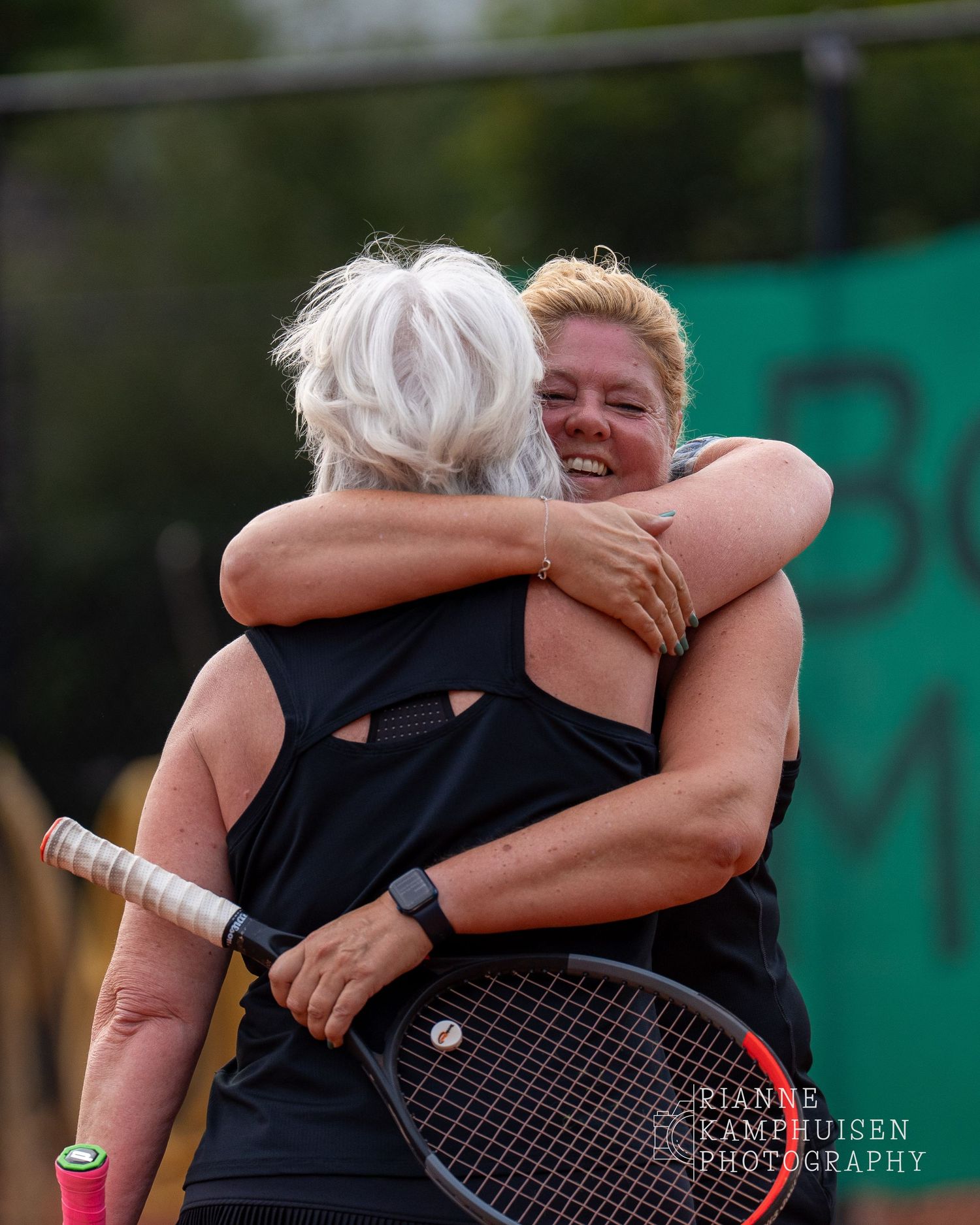 Actiefoto's van gravel tennistoernooi met spelers in actie, dubbelspel, toeschouwers en zomerse sfeer rond de baan.v