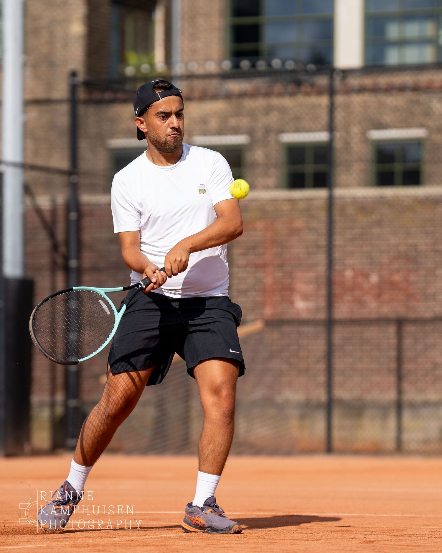Actiefoto's van gravel tennistoernooi met spelers in actie, dubbelspel, toeschouwers en zomerse sfeer rond de baan.