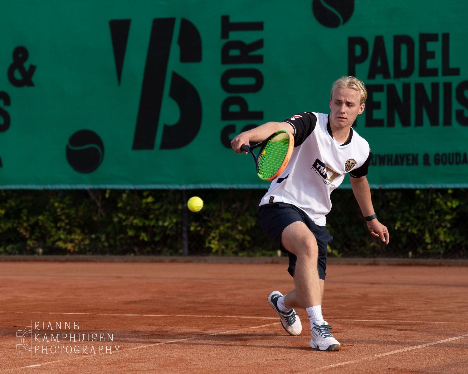 Actiefoto's van gravel tennistoernooi met spelers in actie, dubbelspel, toeschouwers en zomerse sfeer rond de baan.