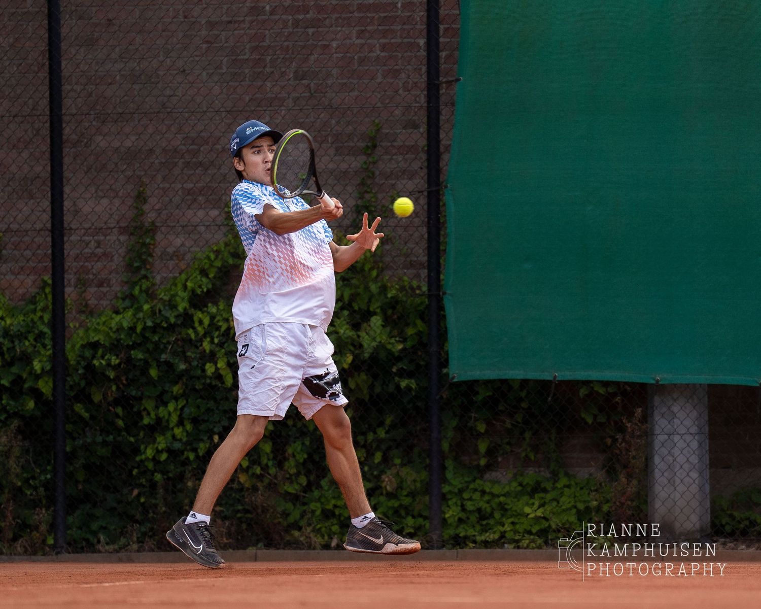 Actiefoto's van de vrijdagavond van een gravel tennistoernooi met spelers in actie, dubbelspel, toeschouwers en zomerse sfeer rond de baan.