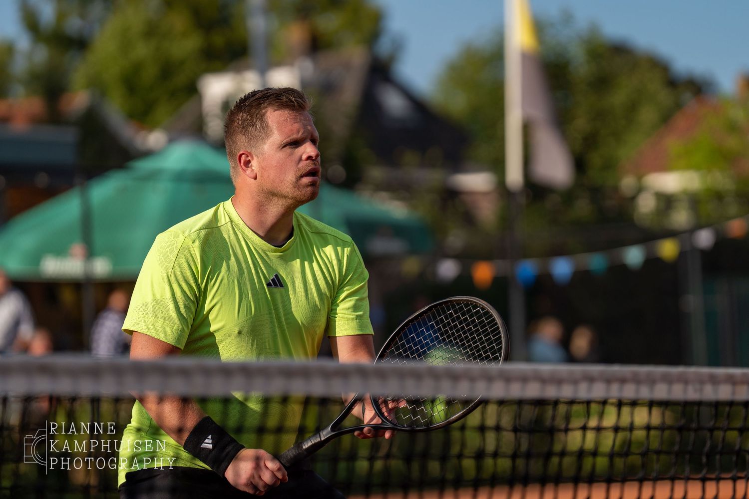 Actiefoto's van gravel tennistoernooi met spelers in actie, dubbelspel, toeschouwers en zomerse sfeer rond de baan.