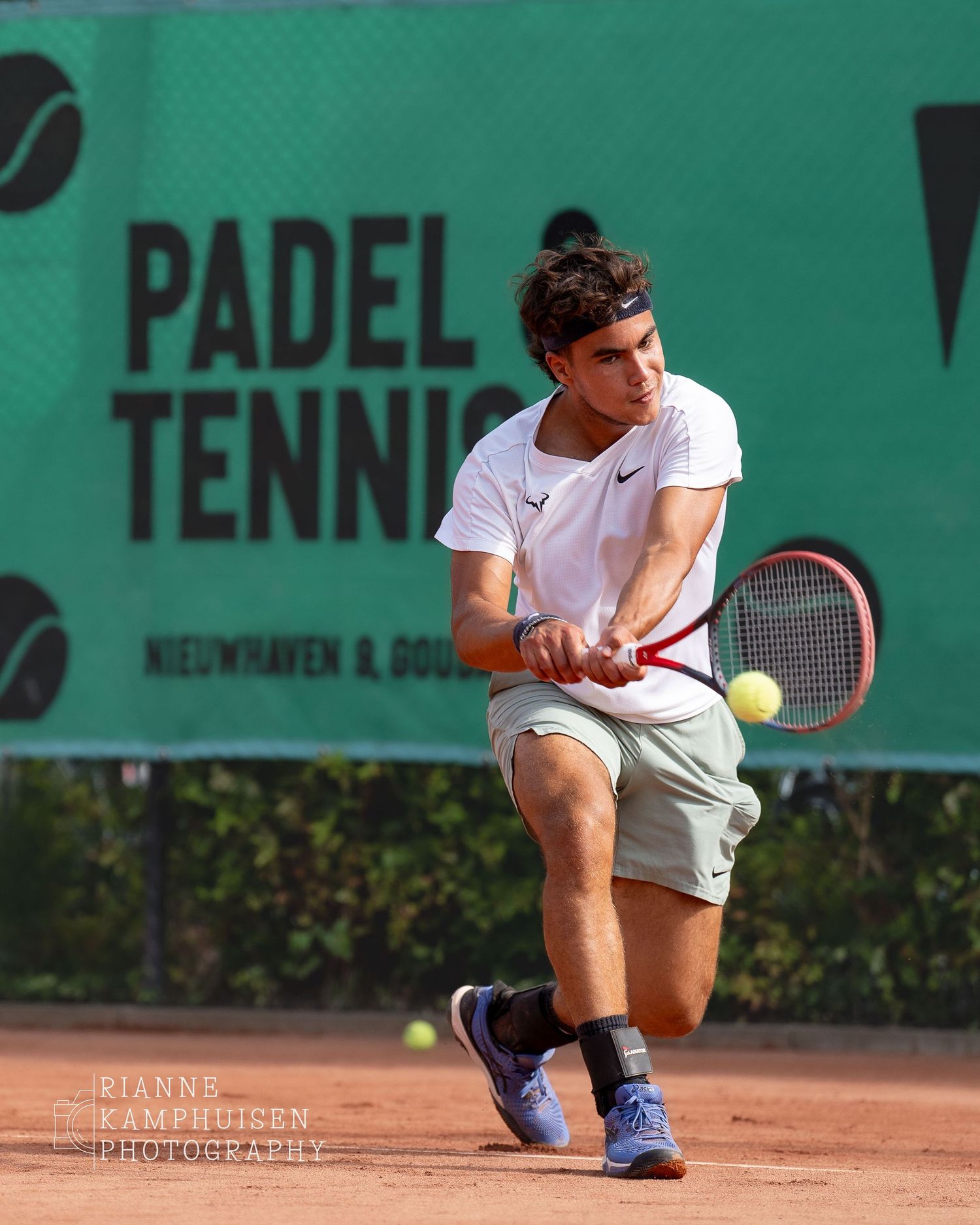 Actiefoto's en finalisten van een gravel tennistoernooi met spelers in actie, dubbelspel, toeschouwers en zomerse sfeer rond de baan.