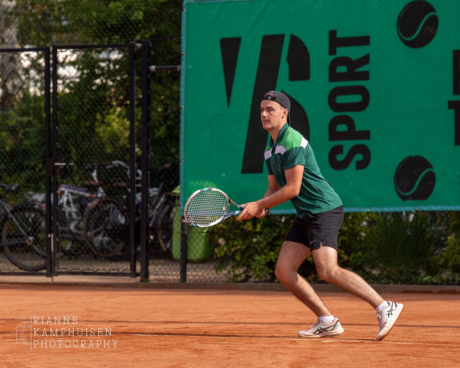Actiefoto's van gravel tennistoernooi met spelers in actie, dubbelspel, toeschouwers en zomerse sfeer rond de baan.