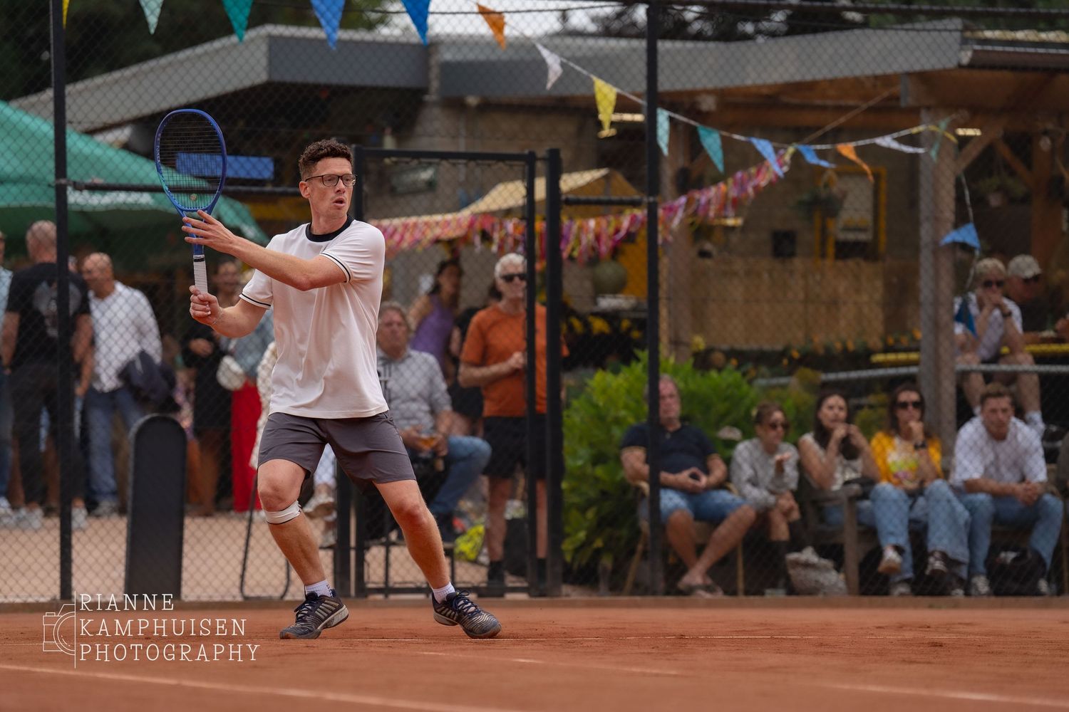Actiefoto's en finalisten van een gravel tennistoernooi met spelers in actie, dubbelspel, toeschouwers en zomerse sfeer rond de baan.