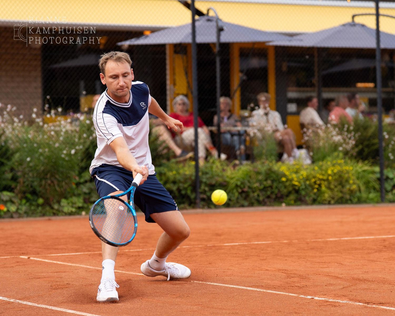 Actiefoto's van gravel tennistoernooi met spelers in actie, dubbelspel, toeschouwers en zomerse sfeer rond de baan.