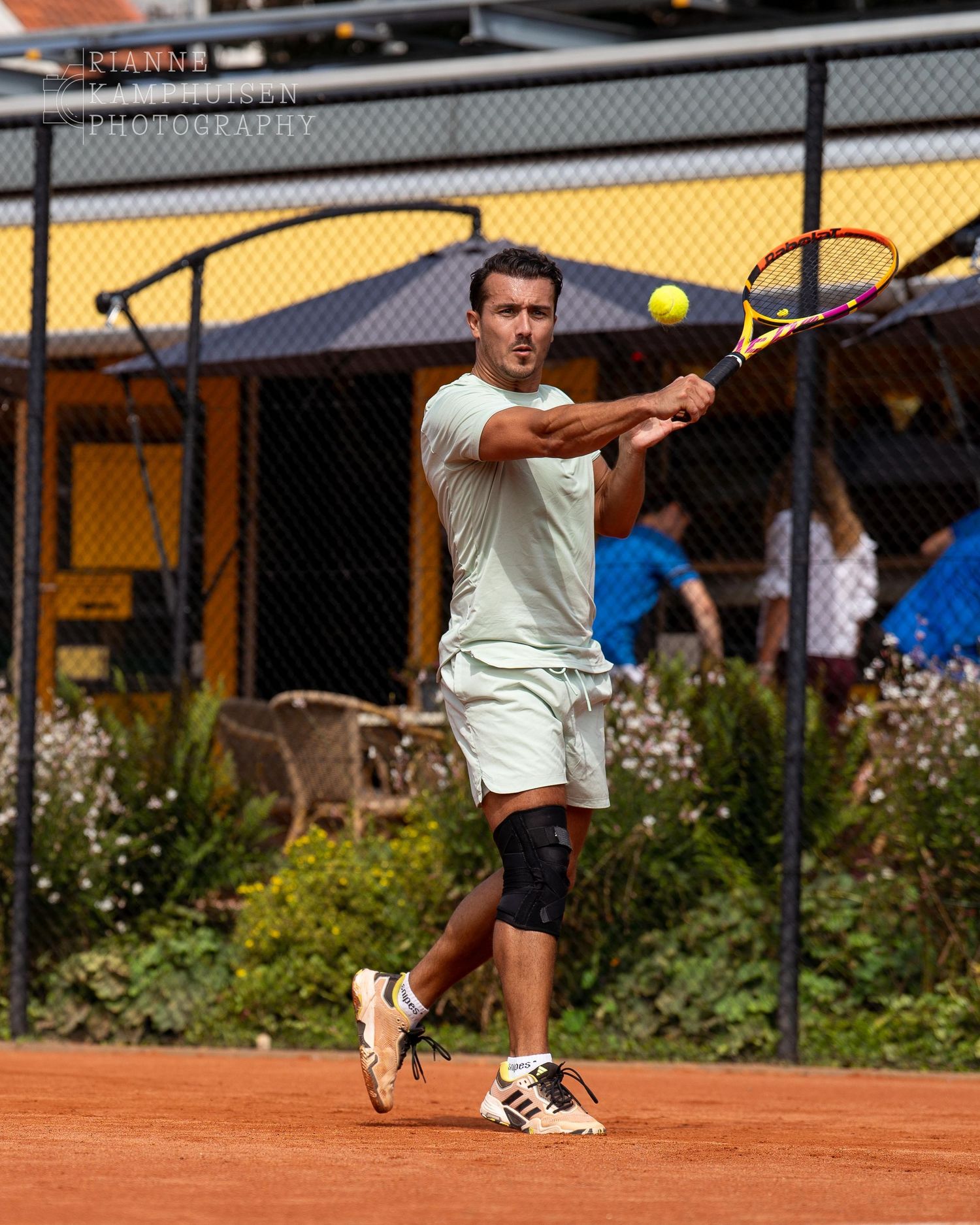 Actiefoto's van gravel tennistoernooi met spelers in actie, dubbelspel, toeschouwers en zomerse sfeer rond de baan.