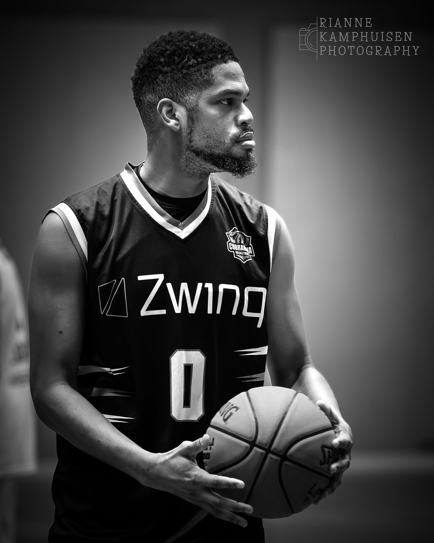 Zwart Wit foto van een basketballer die opzij kijkt met basketbal in zijn handen. Voorburg, Nederland